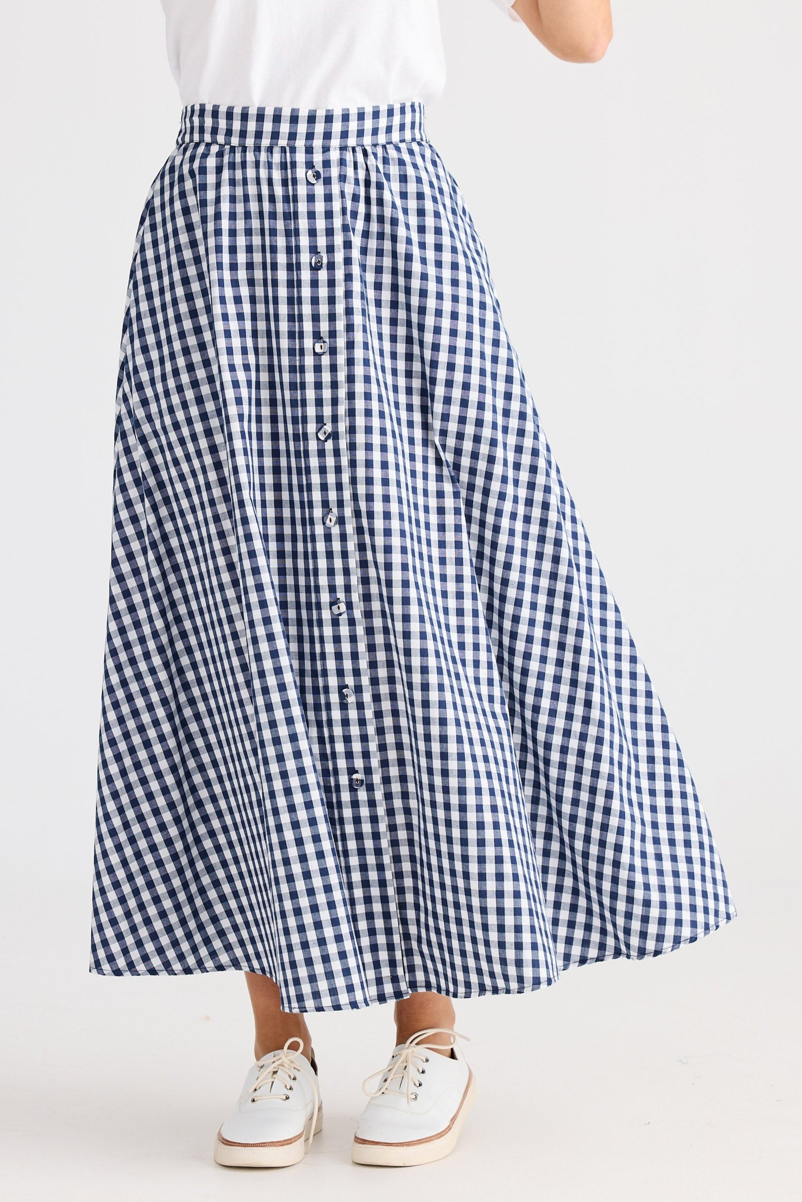 Person wearing a blue and white checkered skirt on a white background