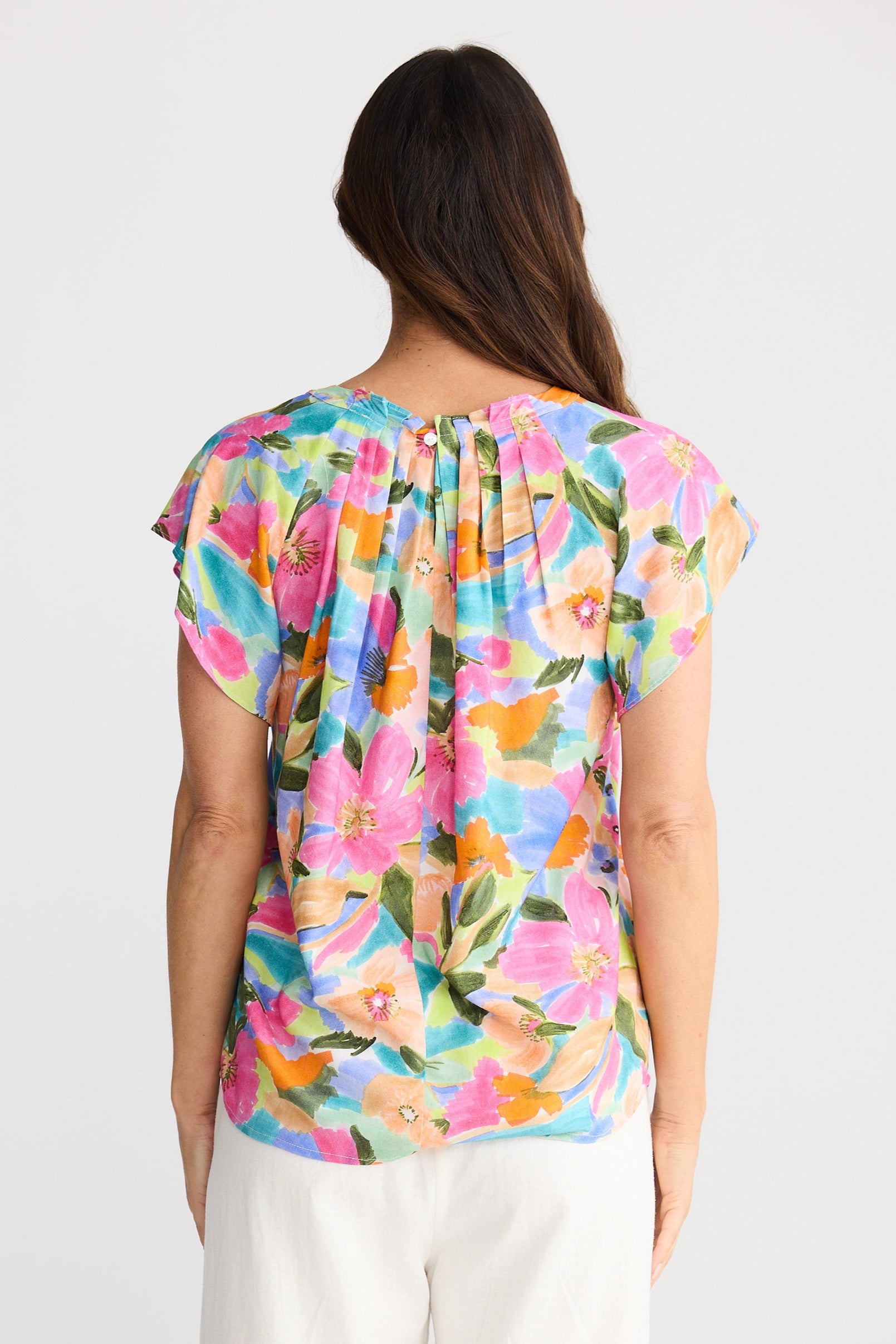 Woman wearing a colorful floral top on a white background