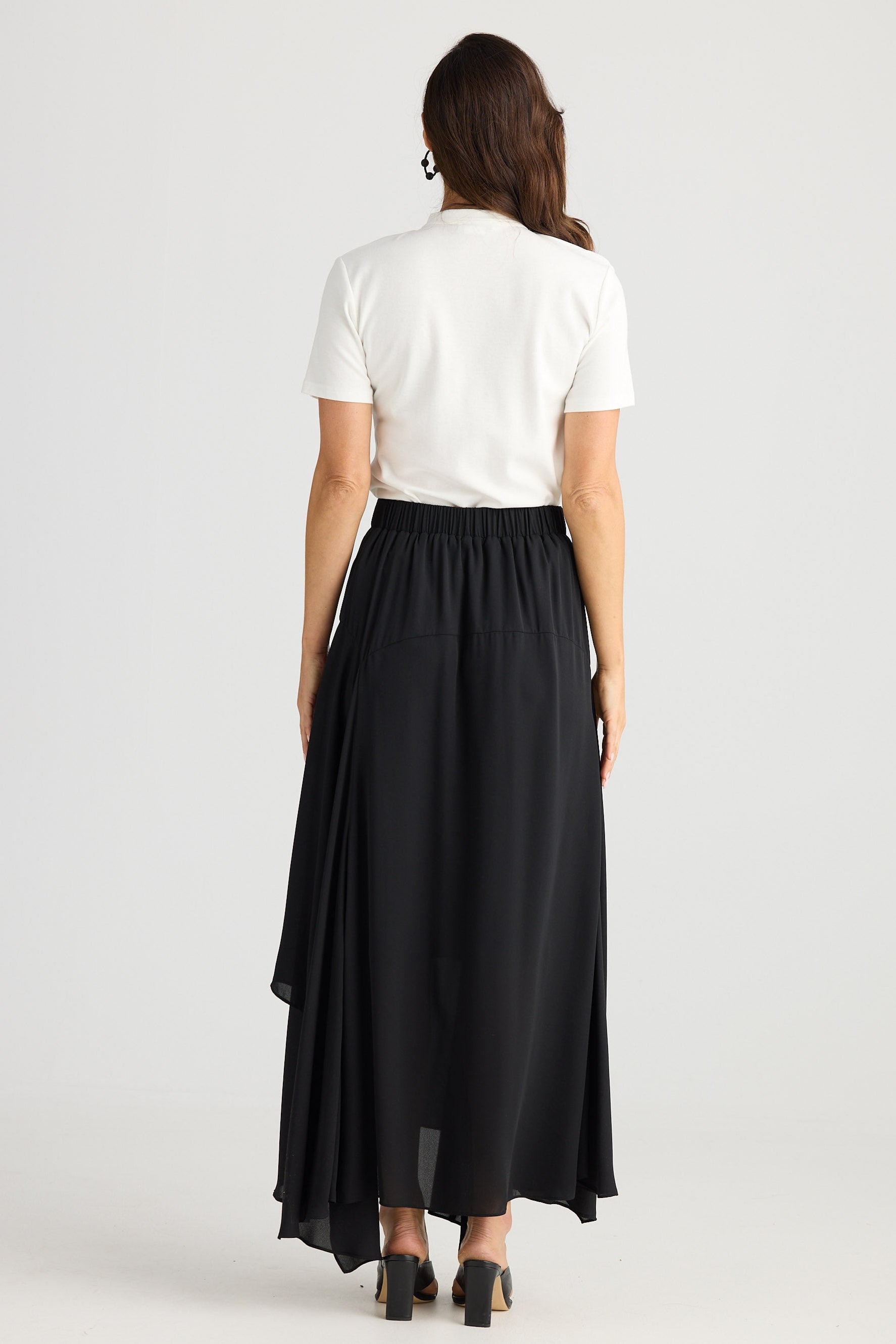 Person wearing a white shirt and black skirt on a white background