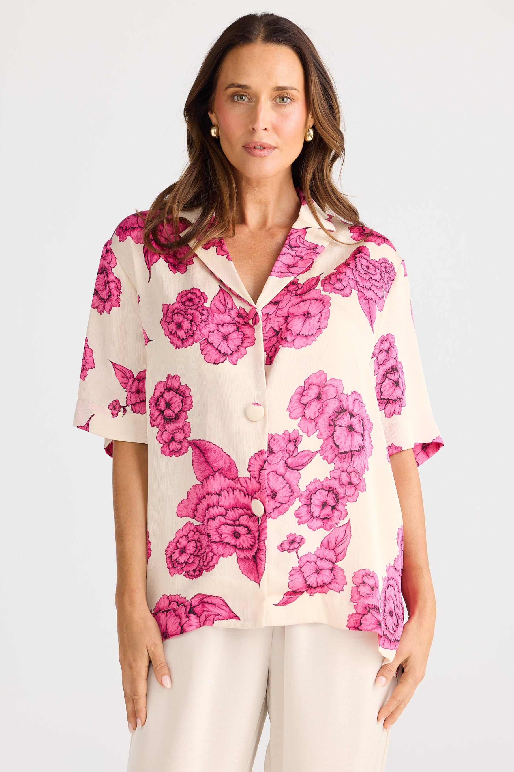 Woman wearing a floral blouse with pink flowers on a white background