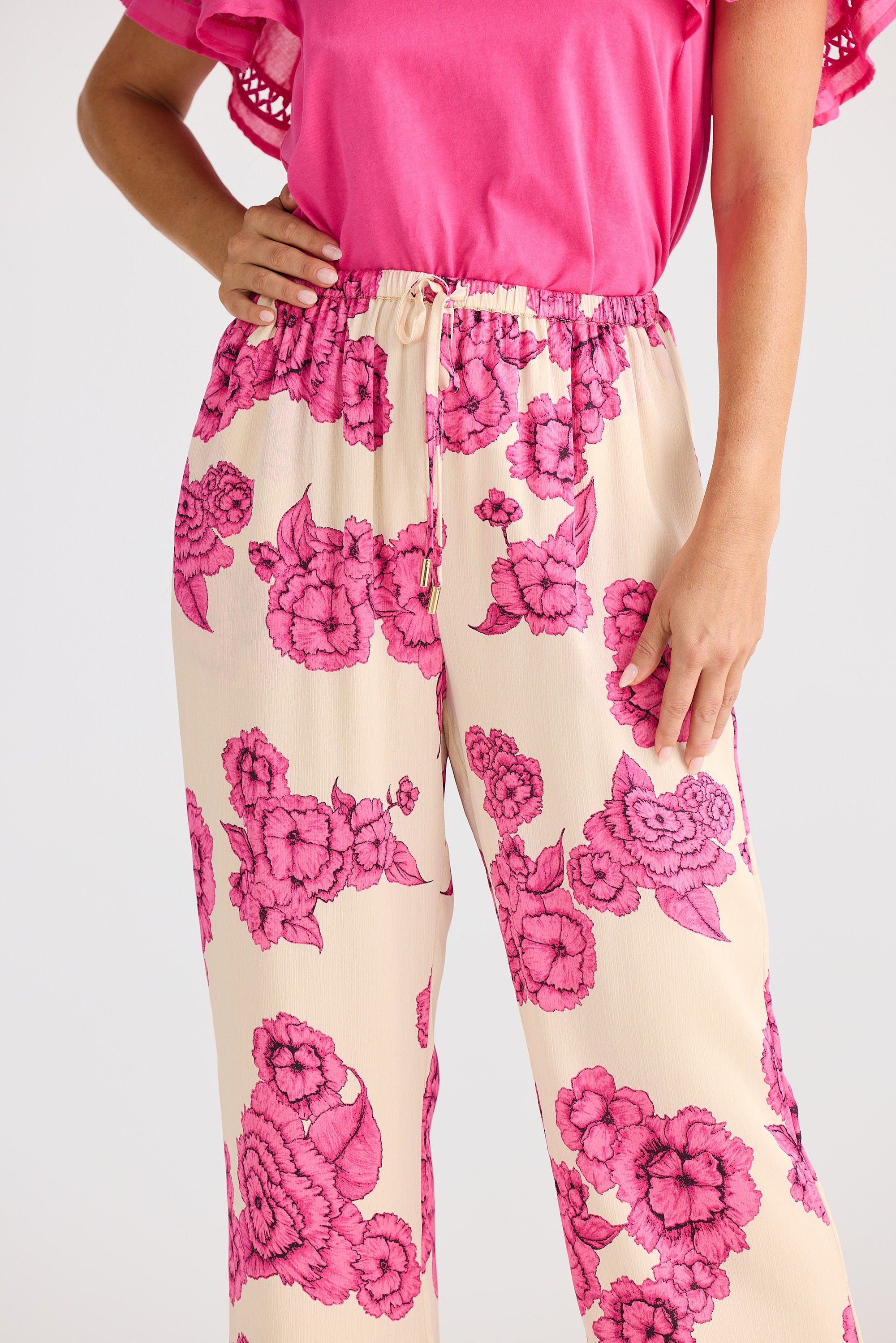 Person wearing a pink floral outfit on a plain background