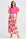 Woman wearing a pink top and floral skirt on a white background