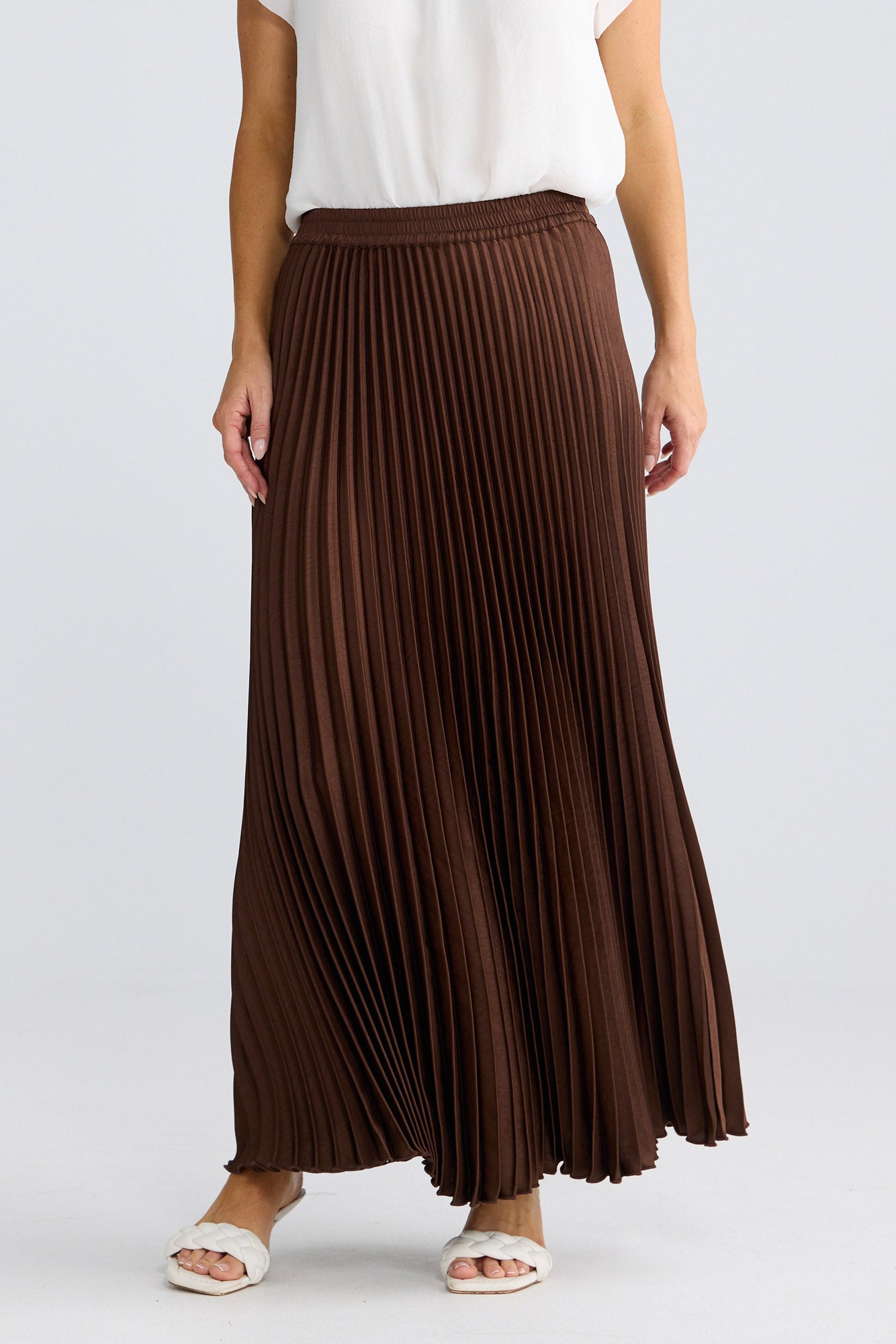 Alias Pleated Skirt in chocolate brown by Brave + True, front view showing elasticated waistband and flowing pleats.