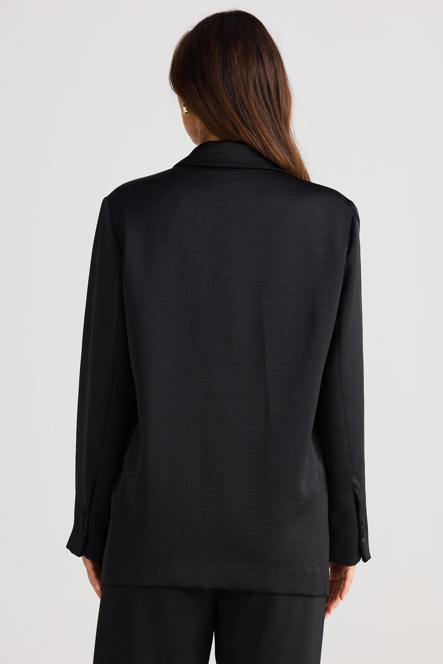 Person wearing a black suit jacket on a white background