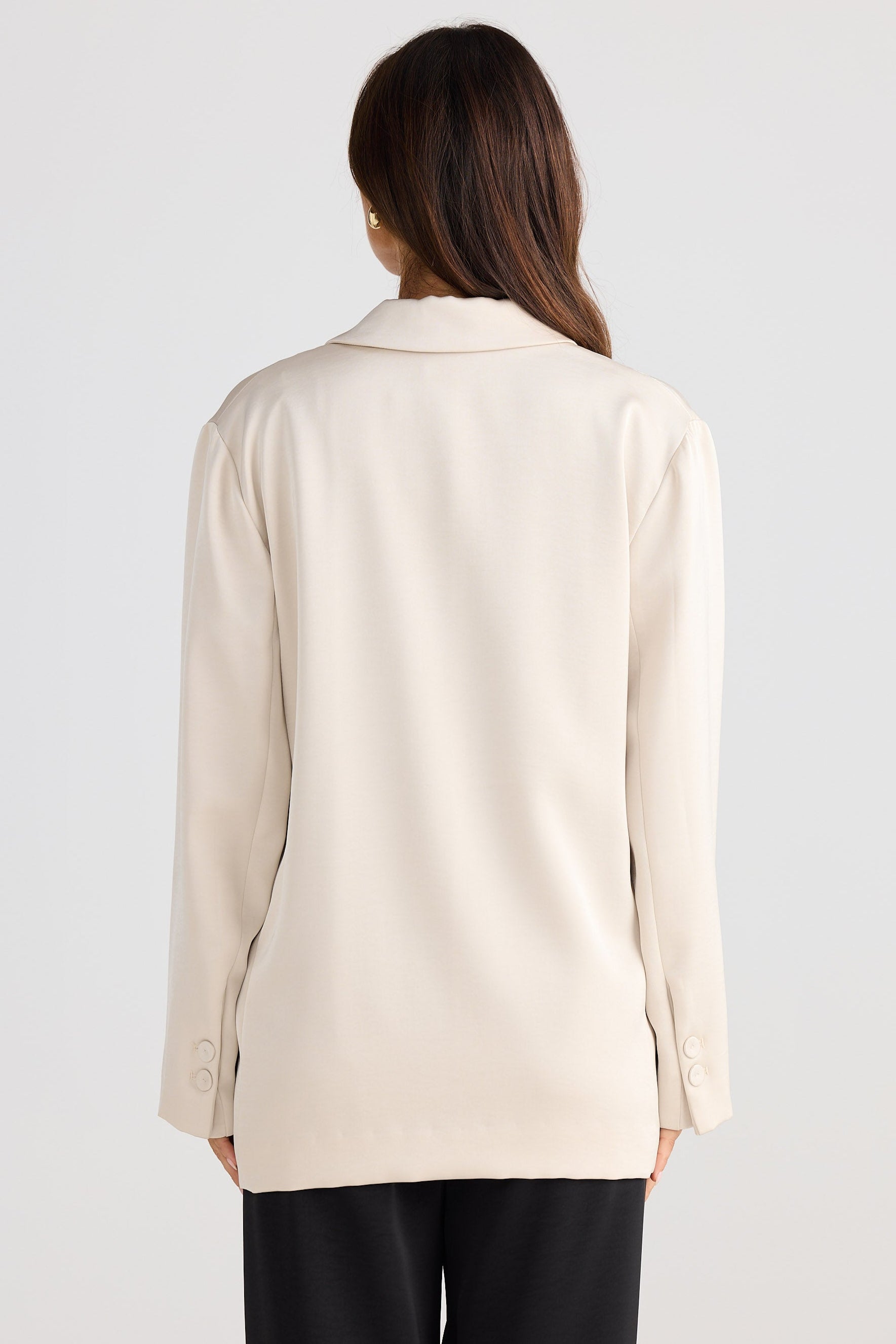 Woman wearing a beige blazer on a white background