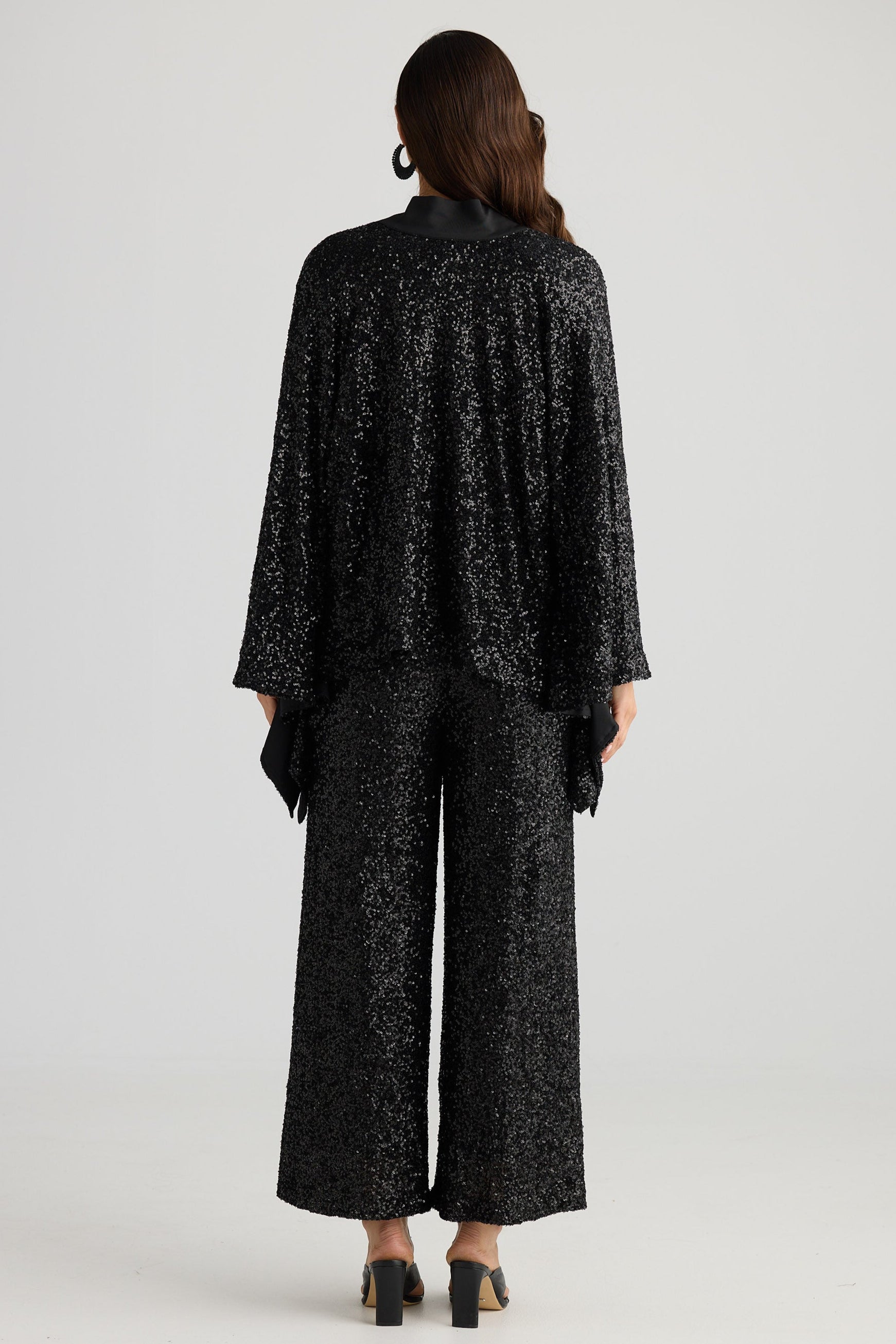 Person wearing a black patterned outfit on a white background