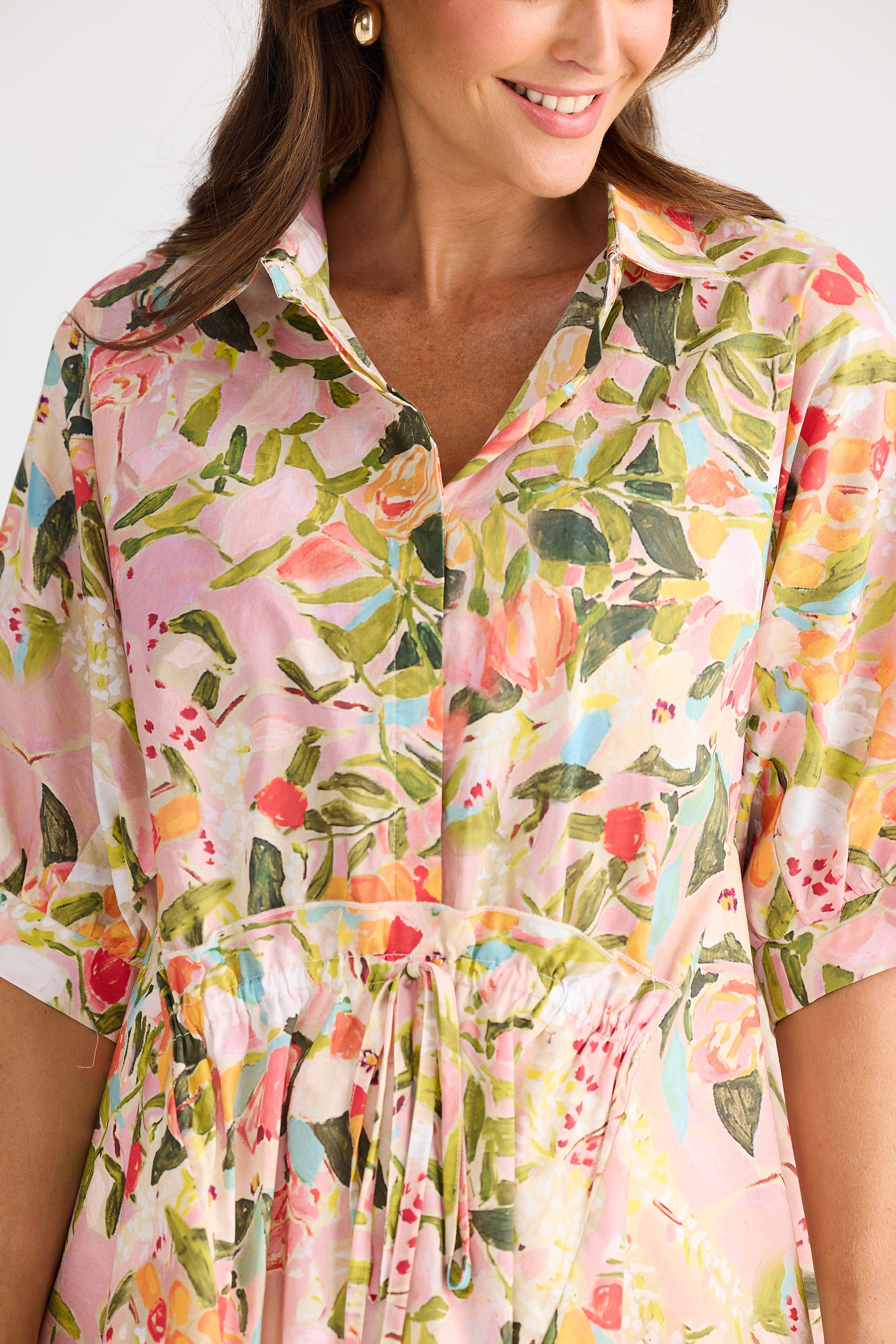 Woman wearing a colorful floral dress with a white background