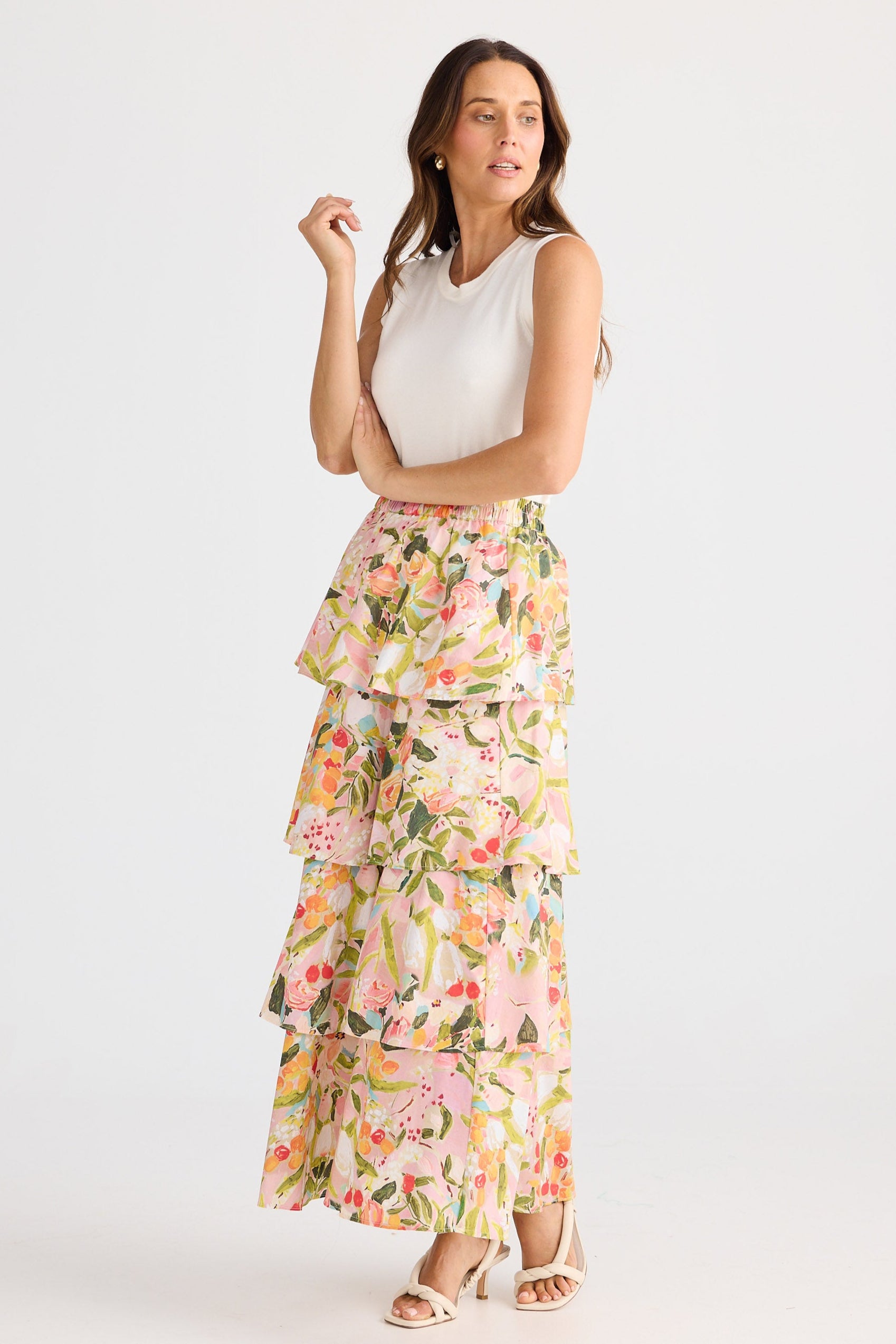 Woman wearing a floral skirt and white top on a white background