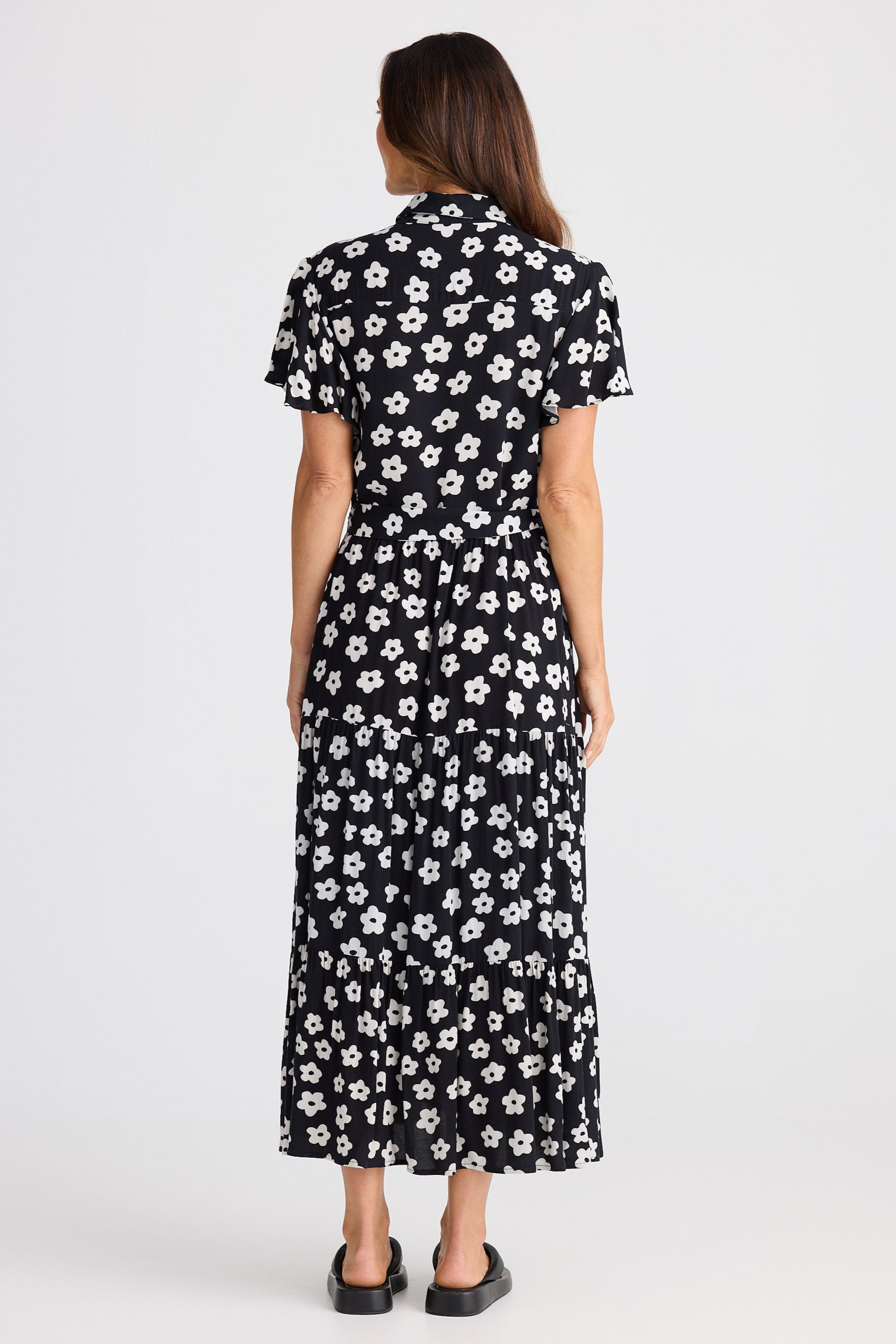 Woman wearing a black floral dress on a white background