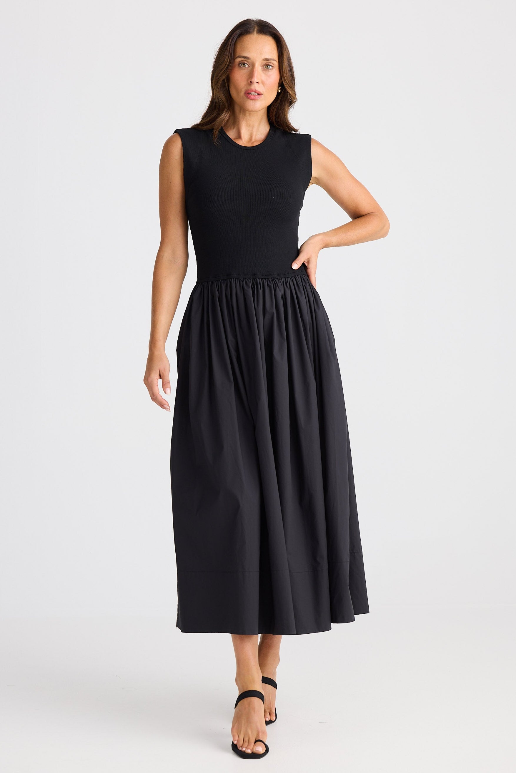Woman wearing a black sleeveless dress on a white background
