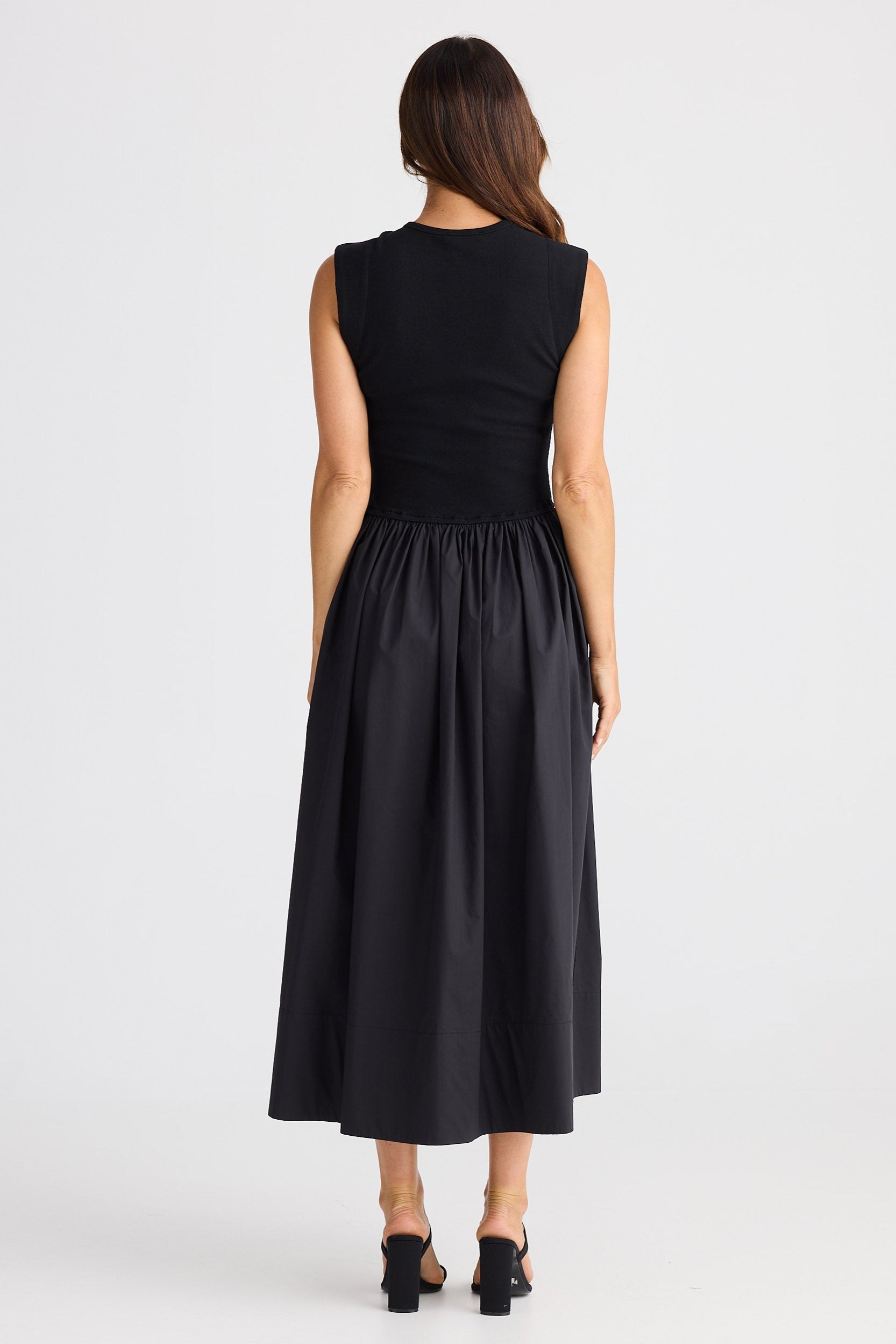Woman wearing a black sleeveless dress on a white background