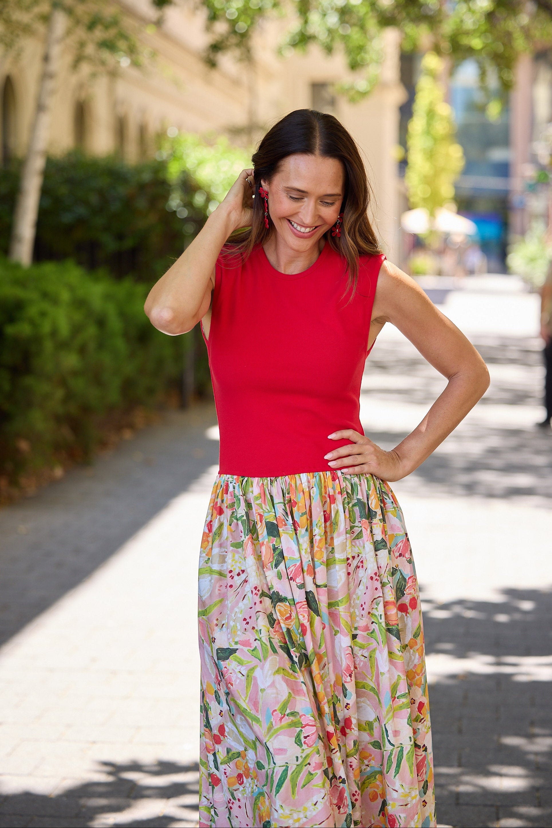 Woman wearing a dress with a red top and floral skirt outdoors