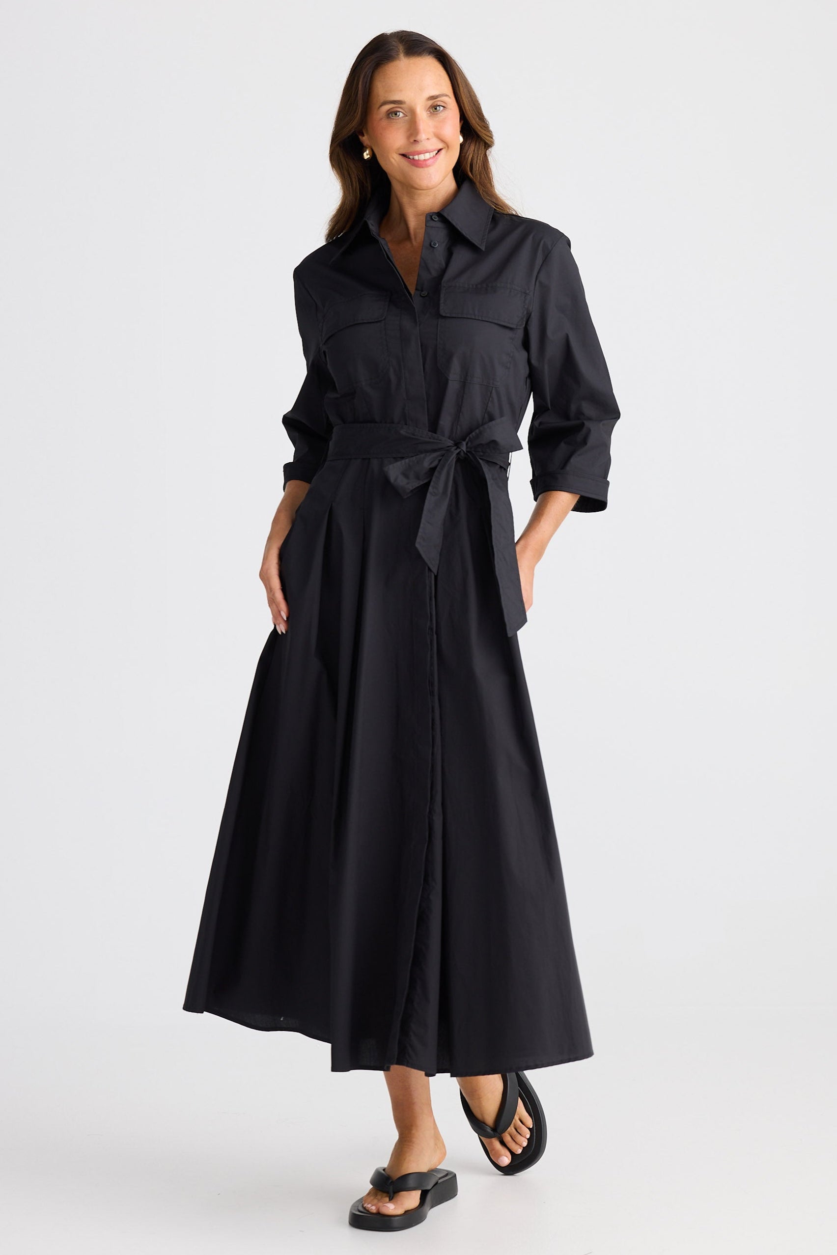 Woman wearing a black dress with a belt on a white background