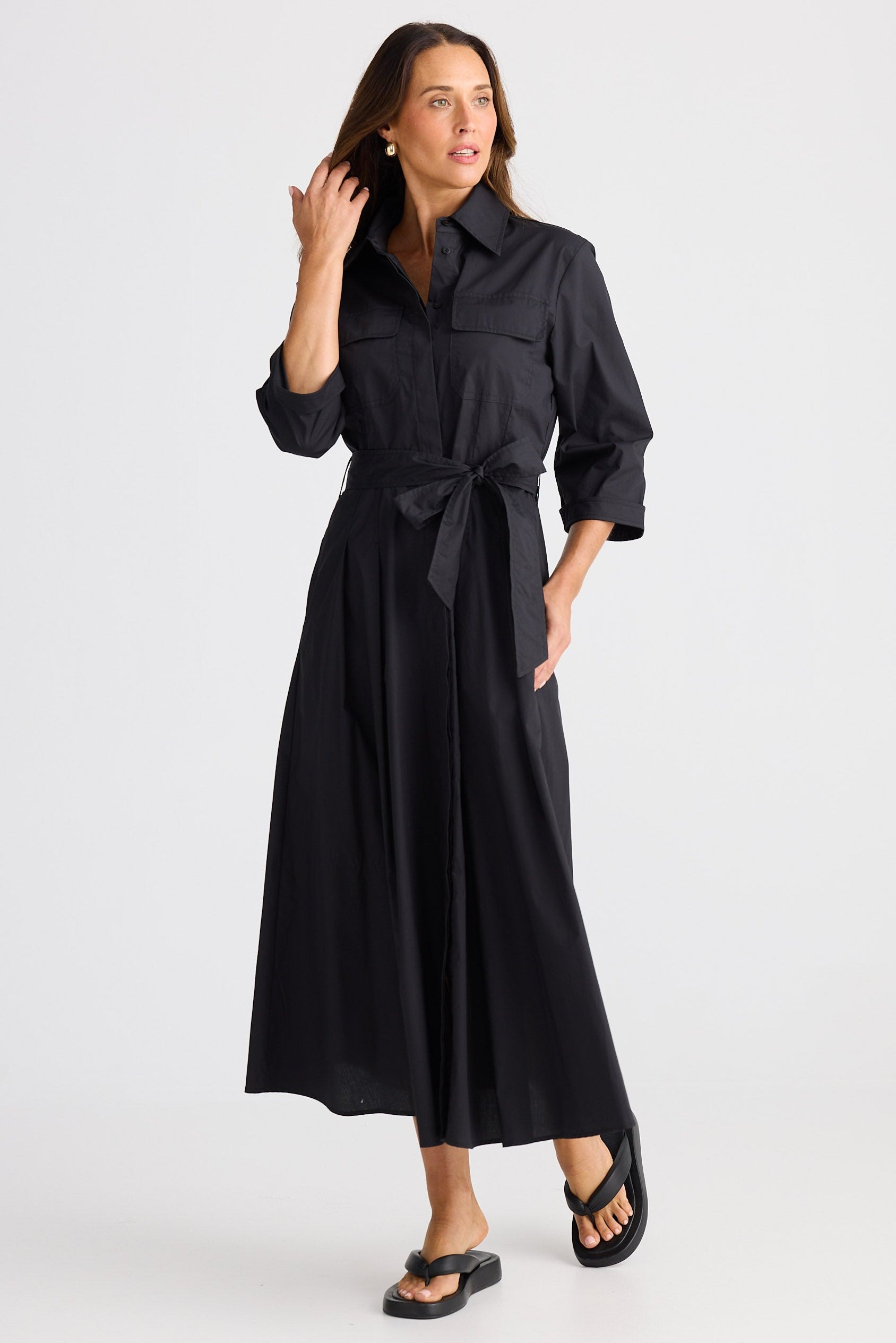 Woman wearing a black dress with a belt on a white background