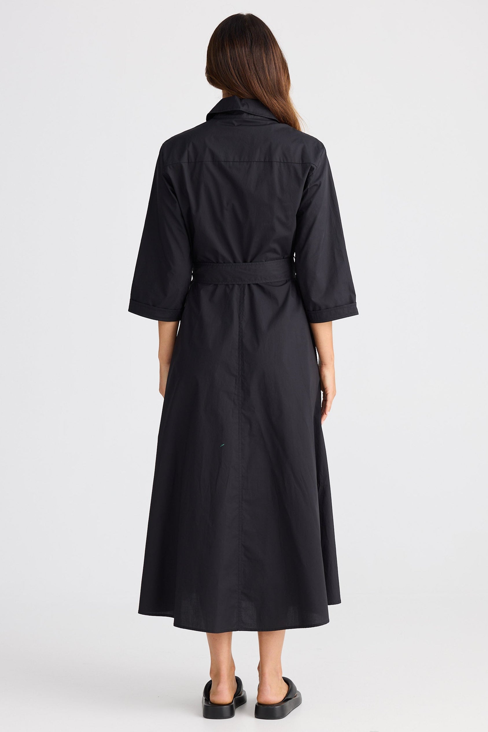 Person wearing a black dress on a white background