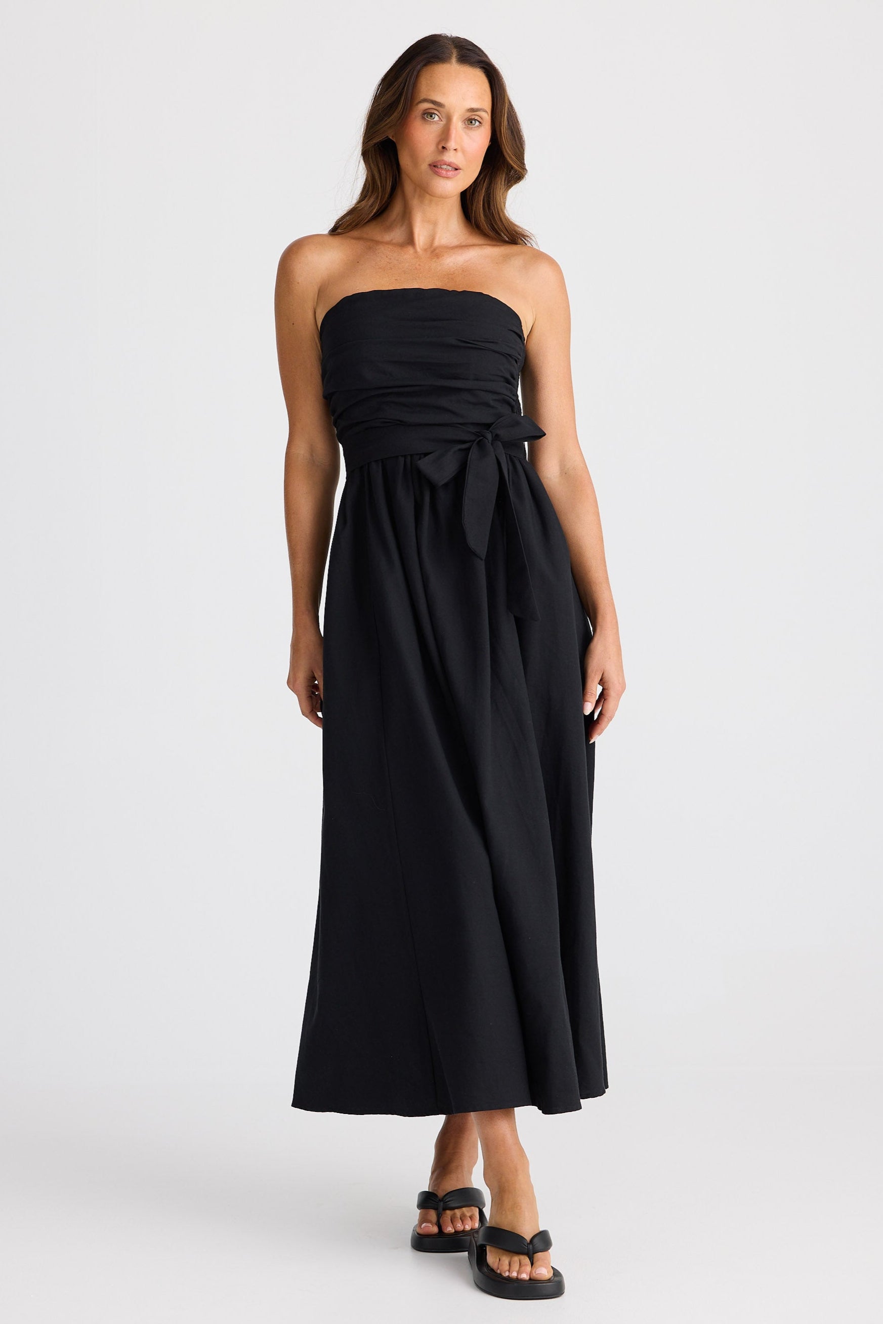 Woman wearing a black strapless dress on a white background