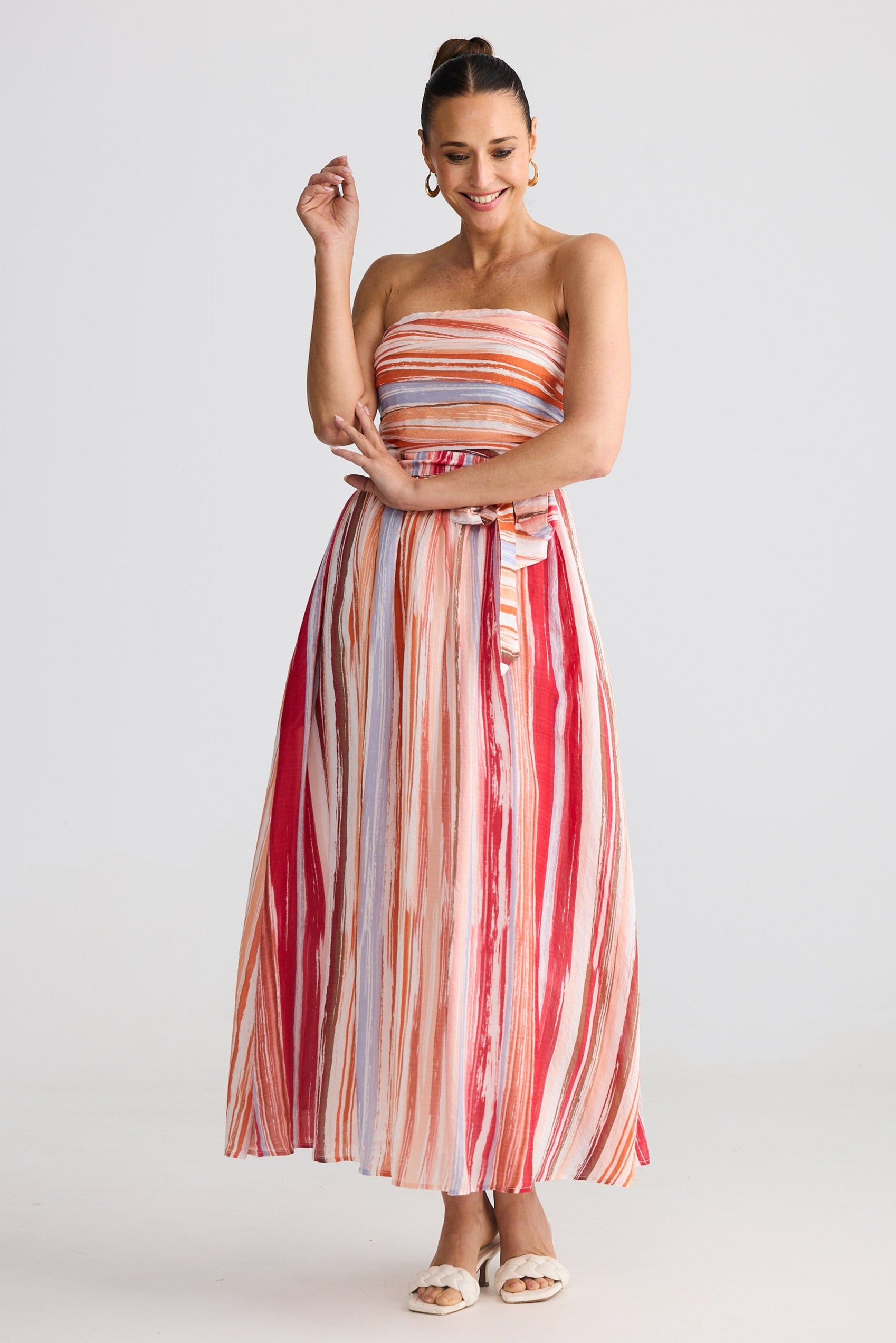 Woman wearing a colorful striped dress on a white background