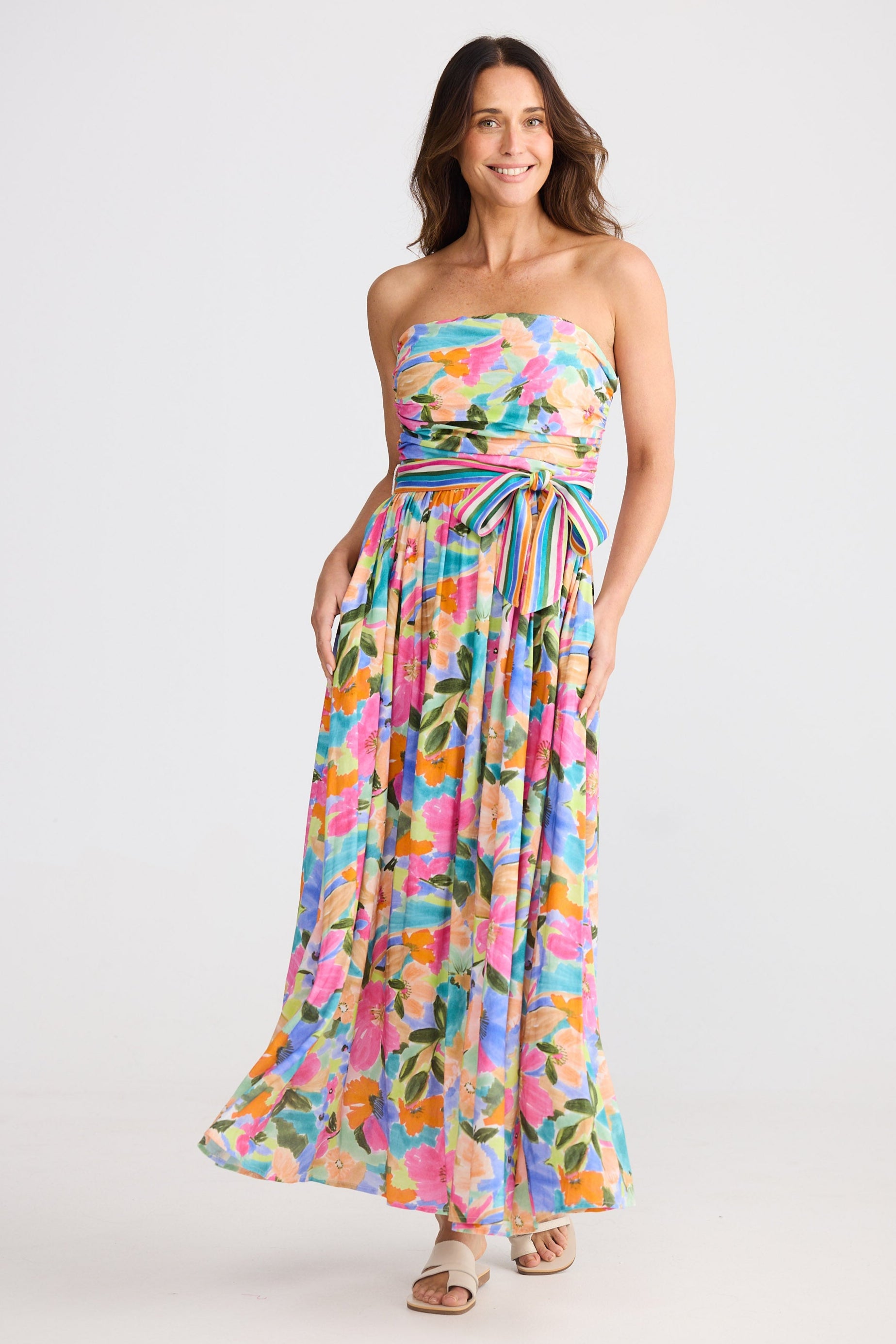 Woman wearing a colorful strapless dress with a white background