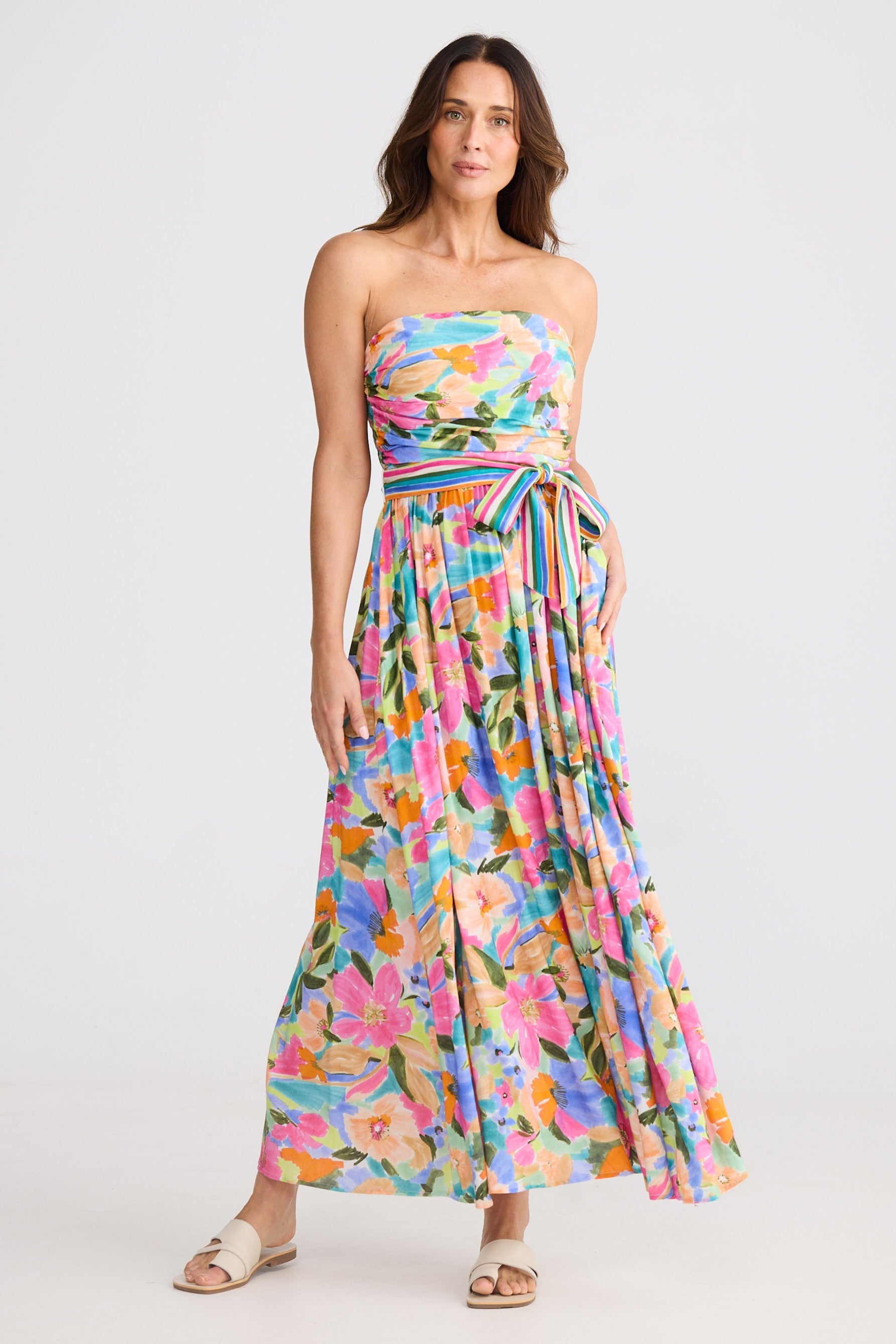 Woman wearing a colorful floral strapless dress on a white background