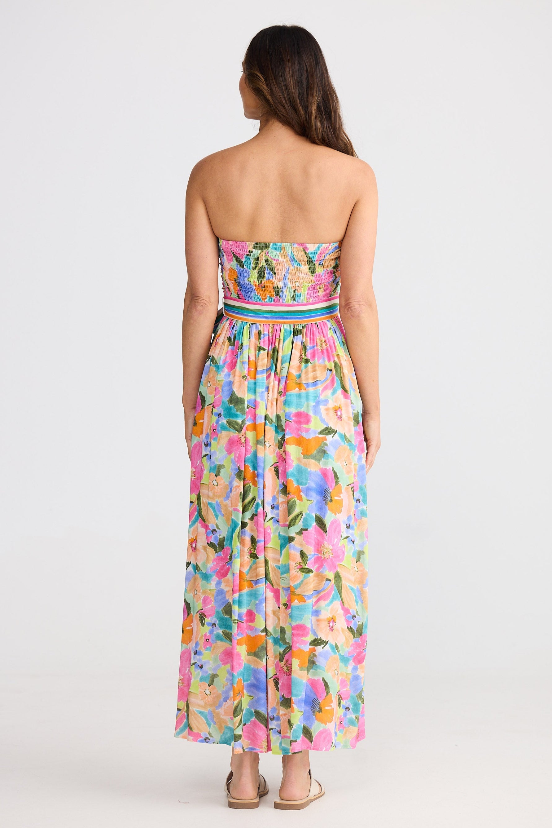 Woman wearing a strapless floral dress on a white background