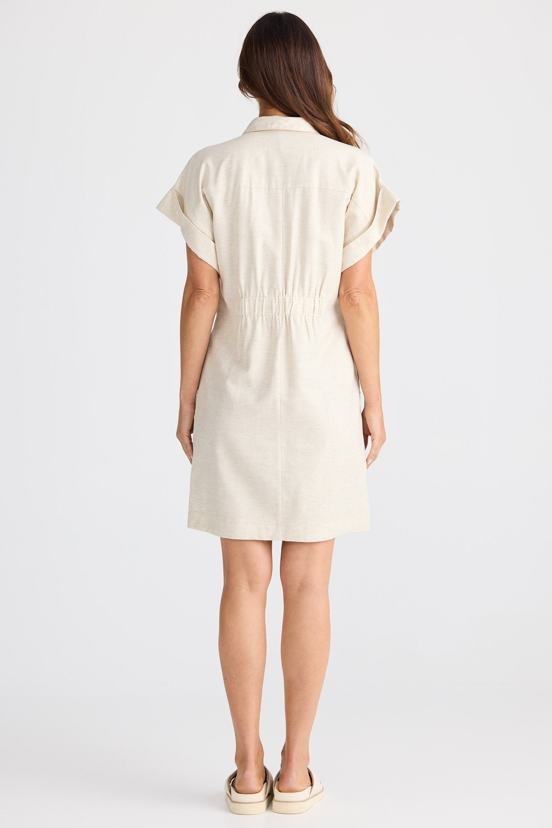 Woman wearing a cream-colored dress on a white background