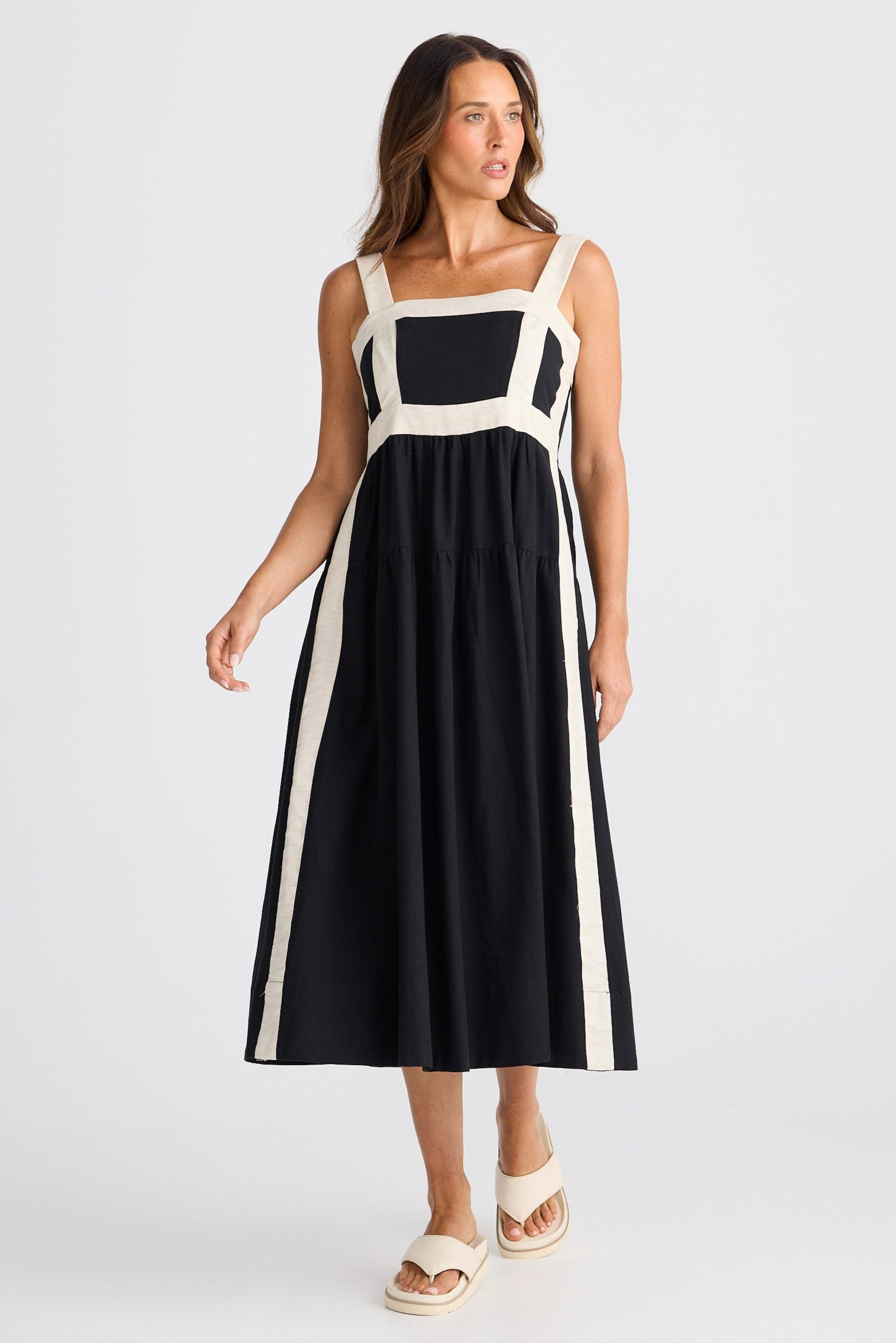 Woman wearing a black and white dress with a white background