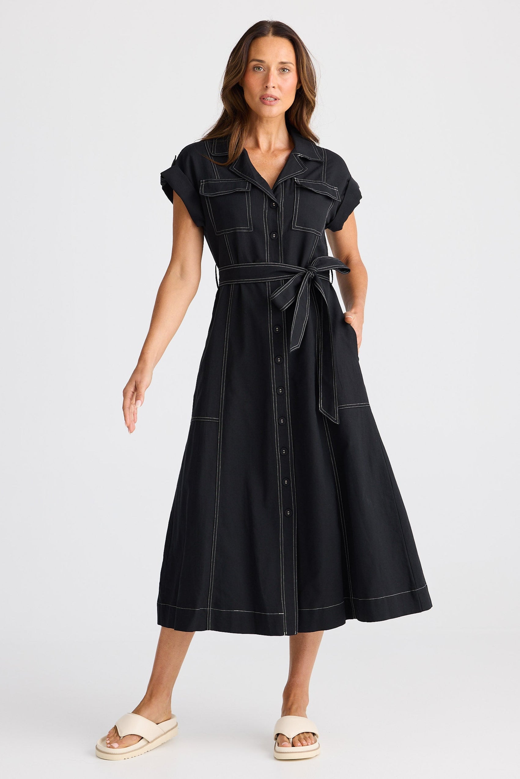 Woman wearing a black dress with a belt on a white background