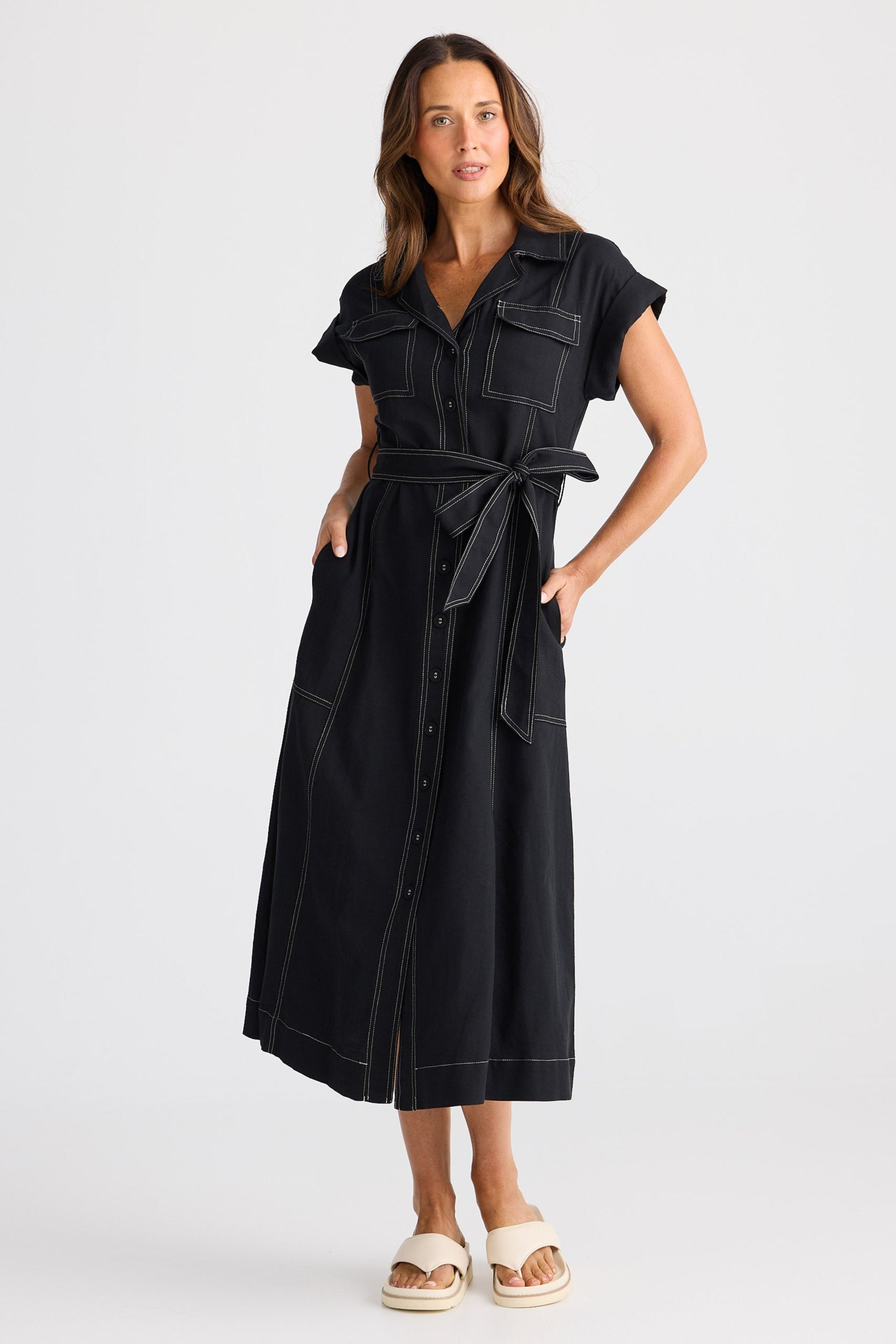 Woman wearing a black dress with a belt on a white background