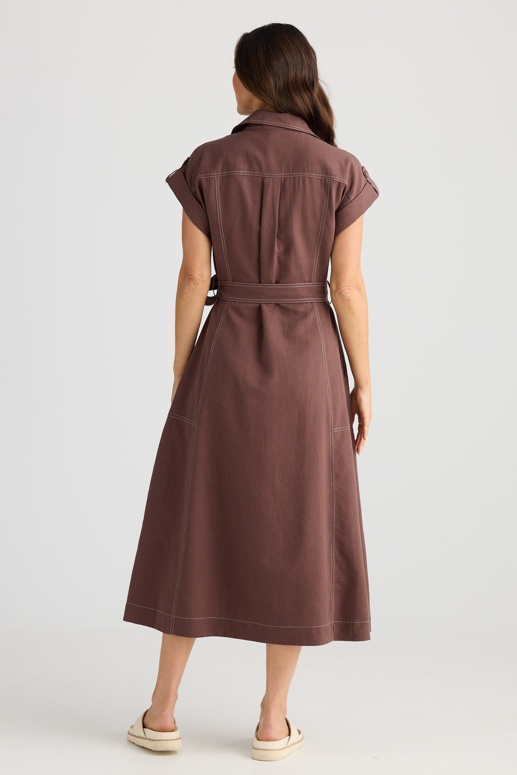 Woman wearing a brown dress against a white background