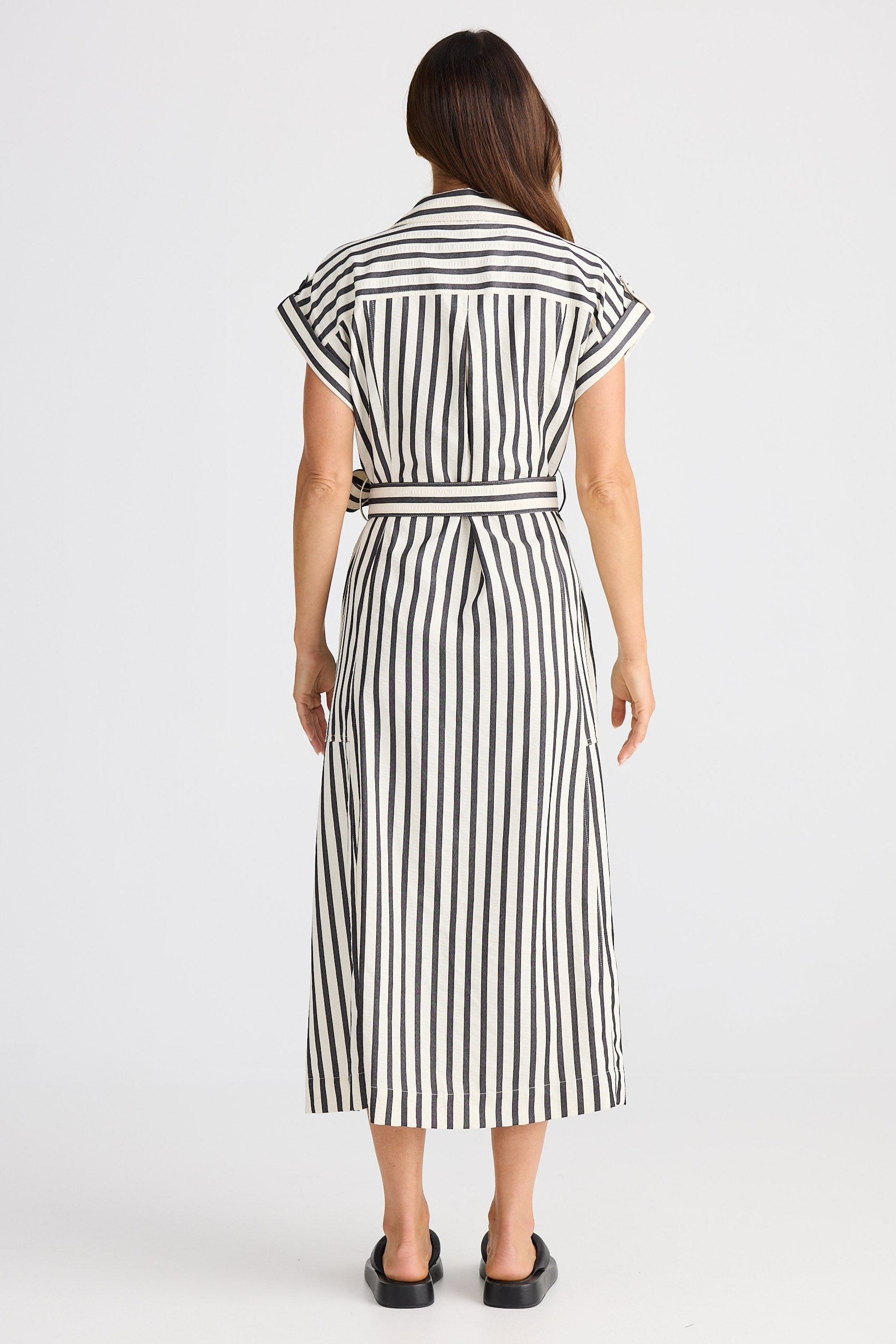 Woman wearing a black and white striped dress on a white background