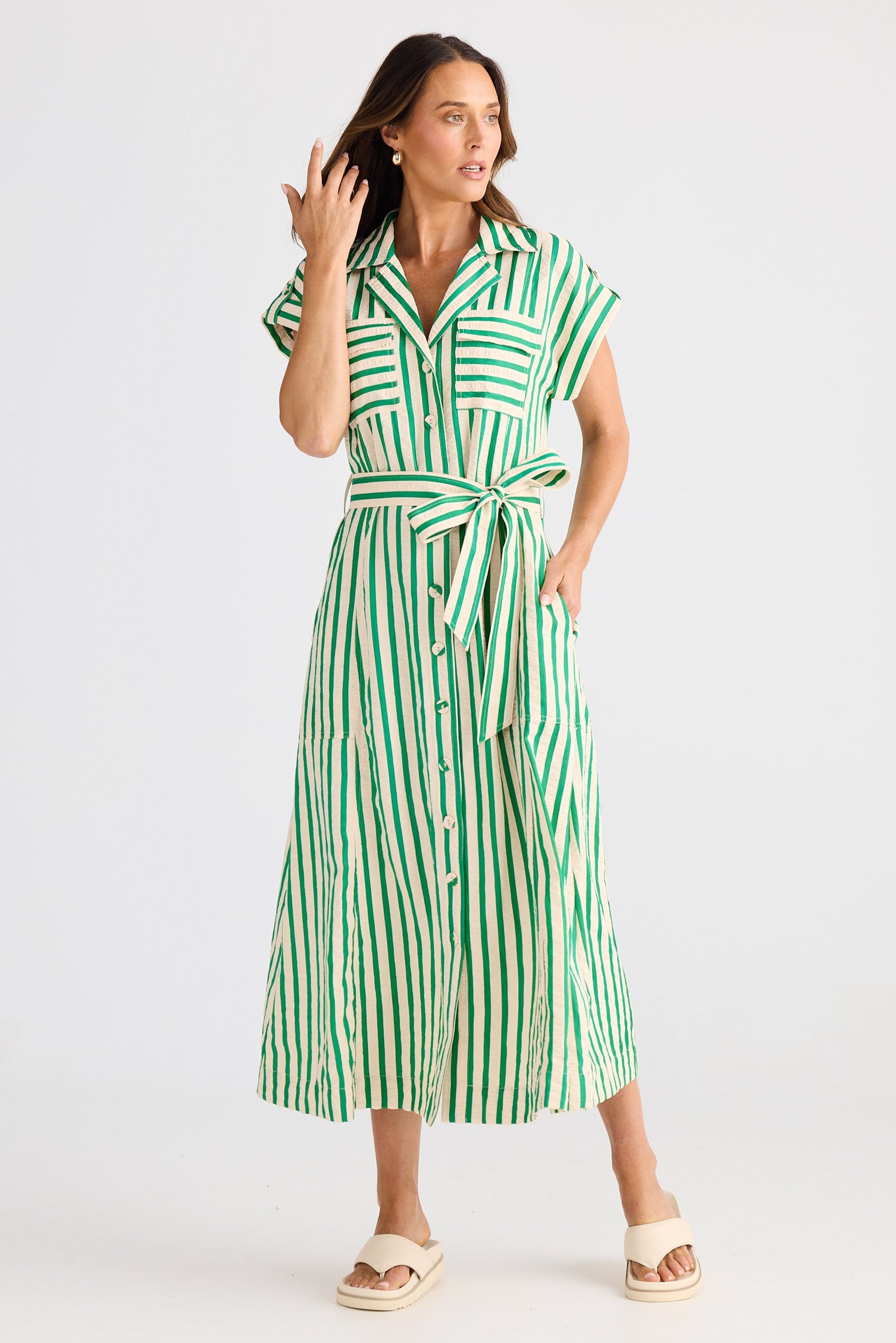Woman wearing a green and white striped dress on a white background