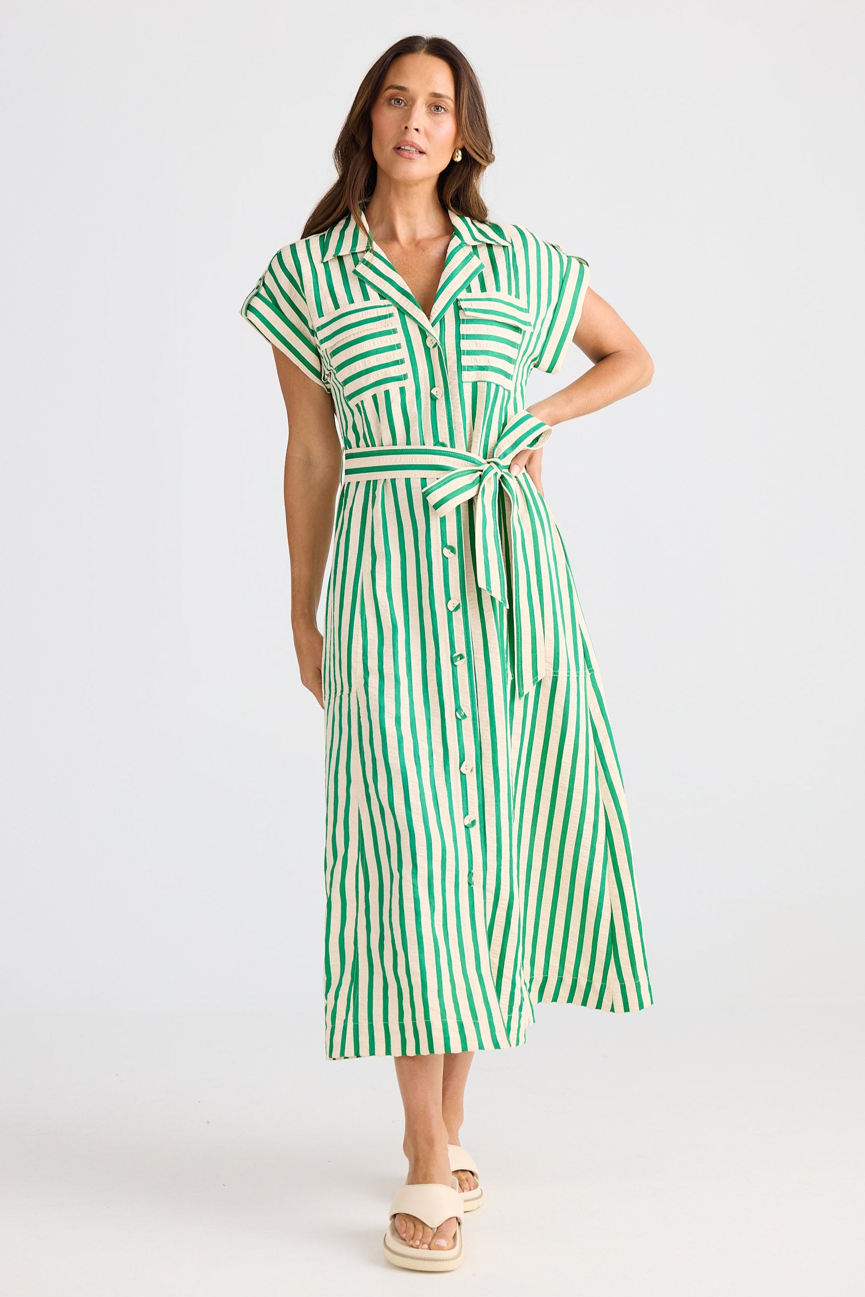 Woman wearing a green and white striped dress on a white background