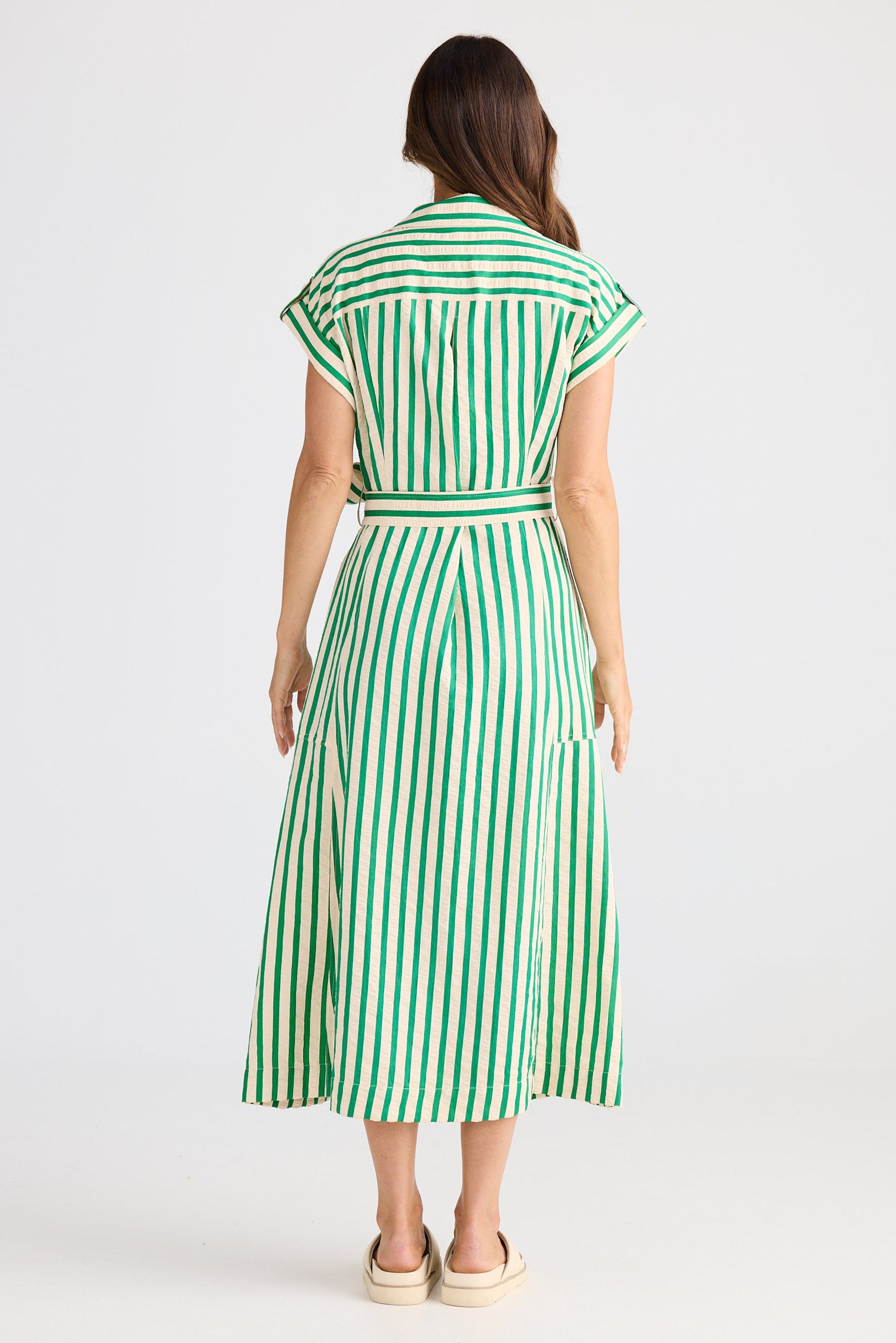 Woman wearing a green and white striped dress on a white background