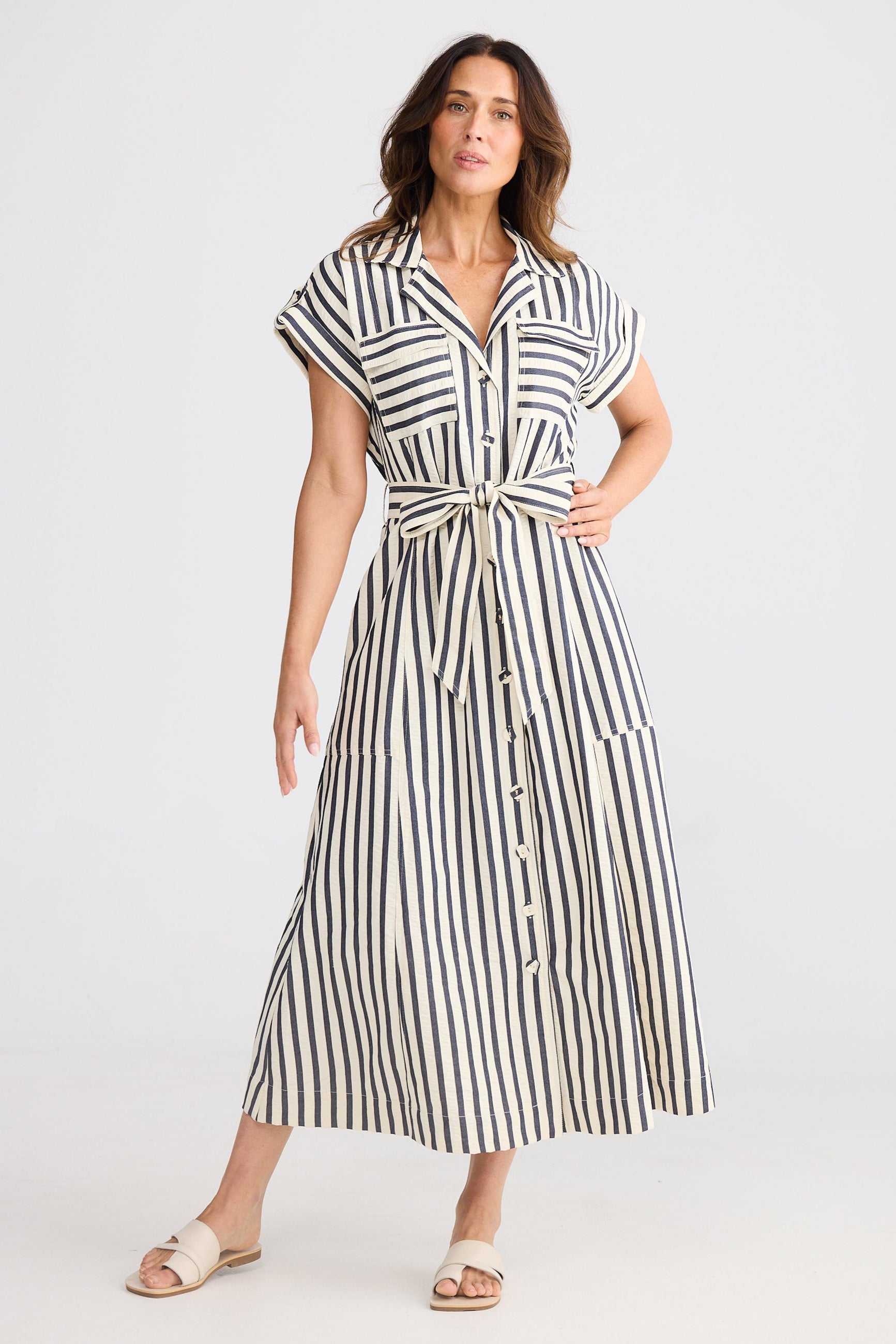 Woman wearing a navy and white striped dress on a white background