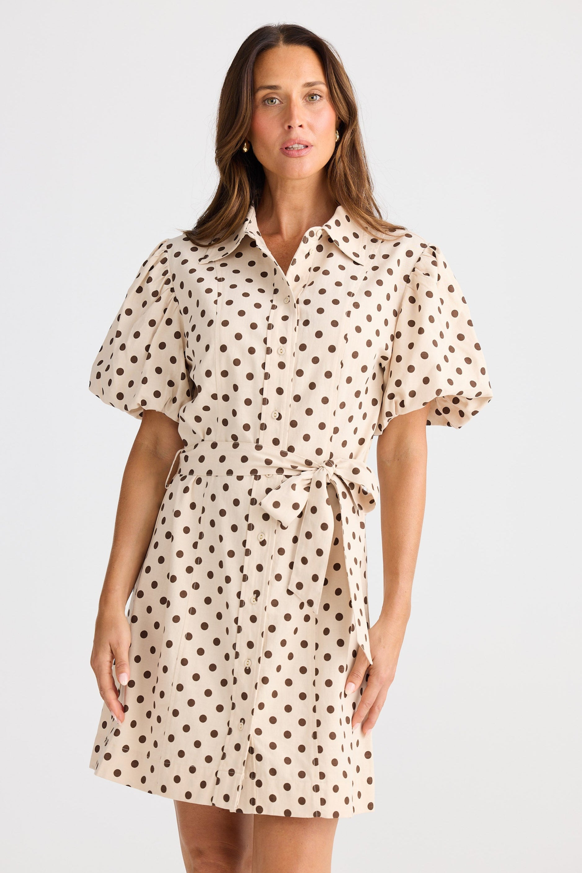 Woman wearing a polka dot dress on a white background