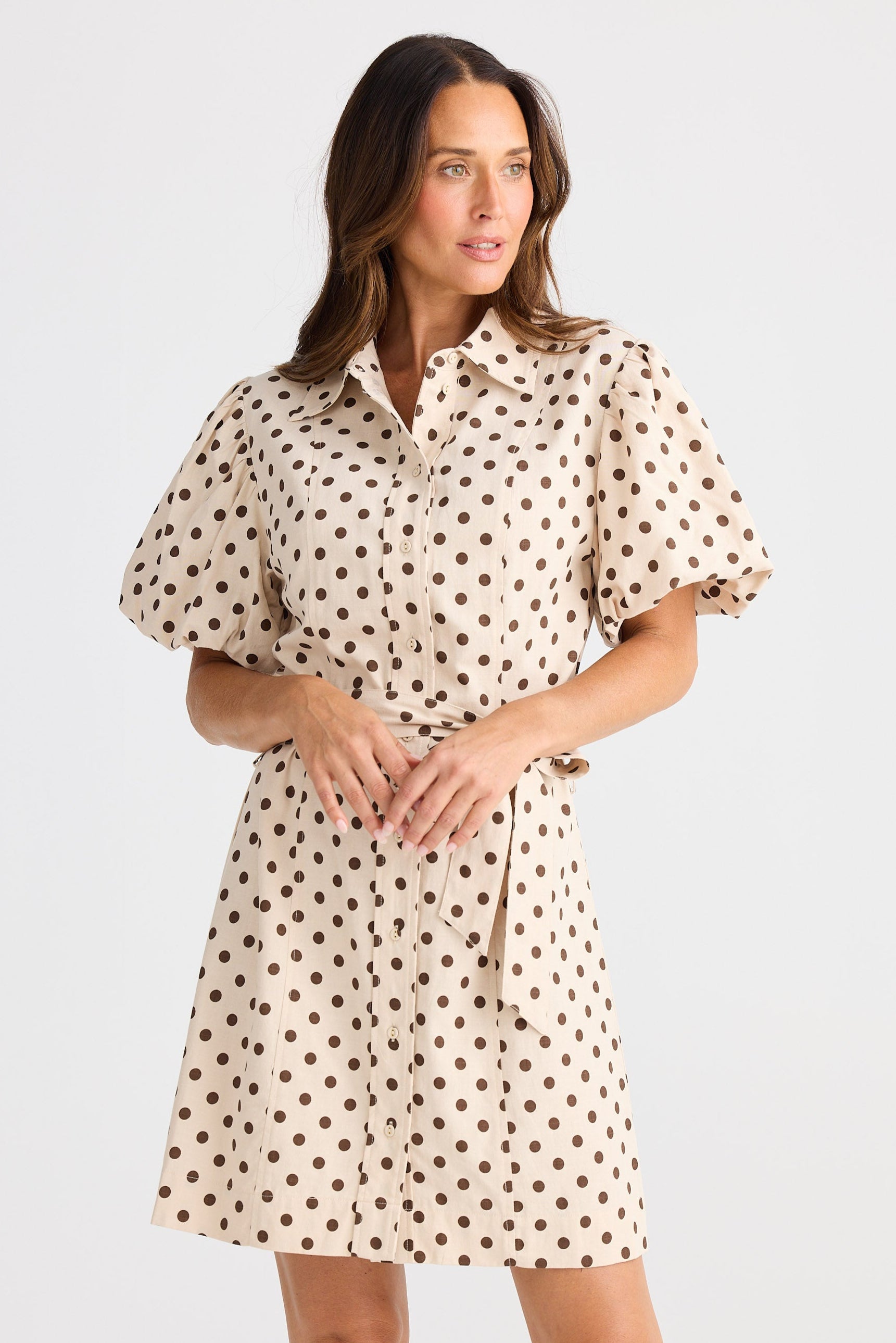 Woman wearing a polka dot dress on a white background