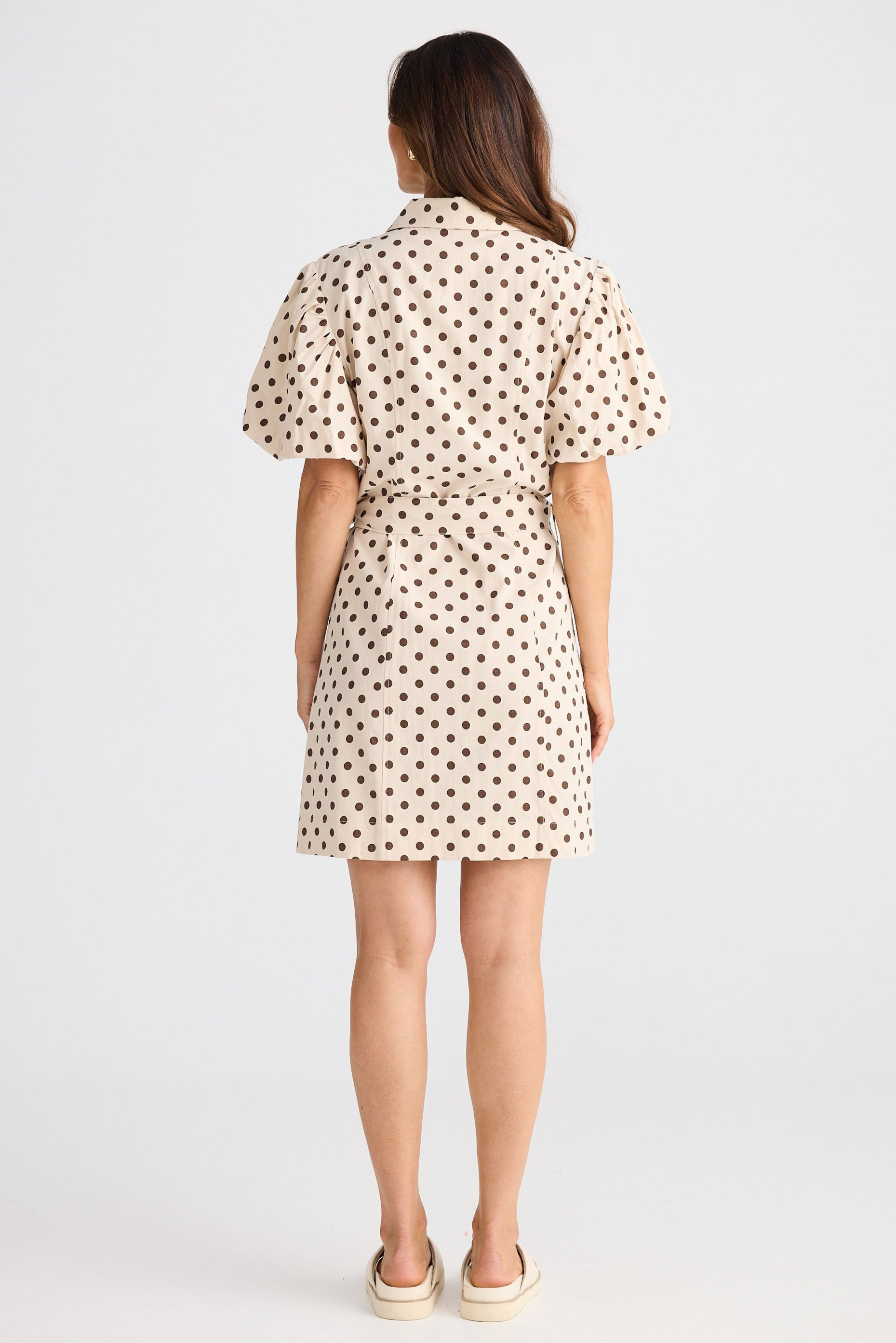 Woman wearing a polka dot dress on a white background