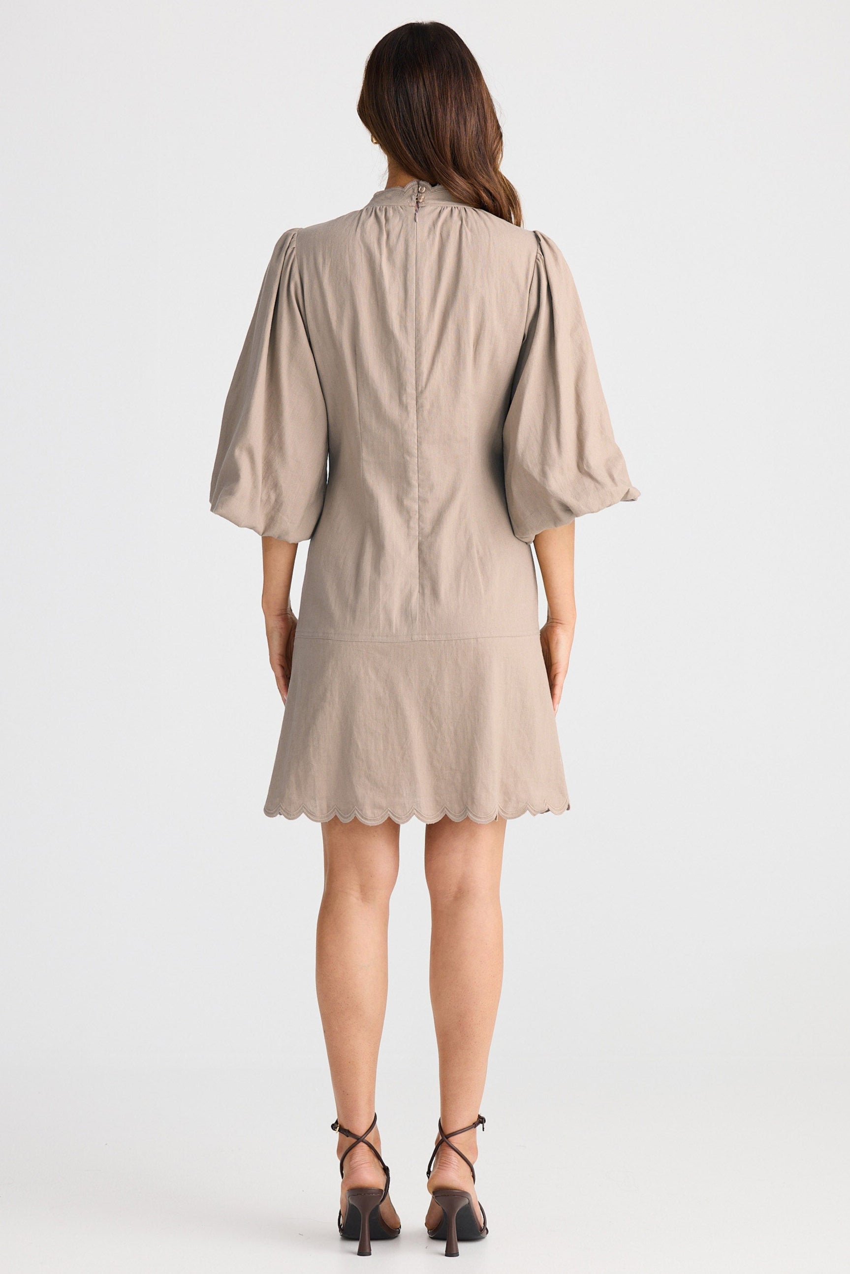 Woman wearing a beige dress on a white background
