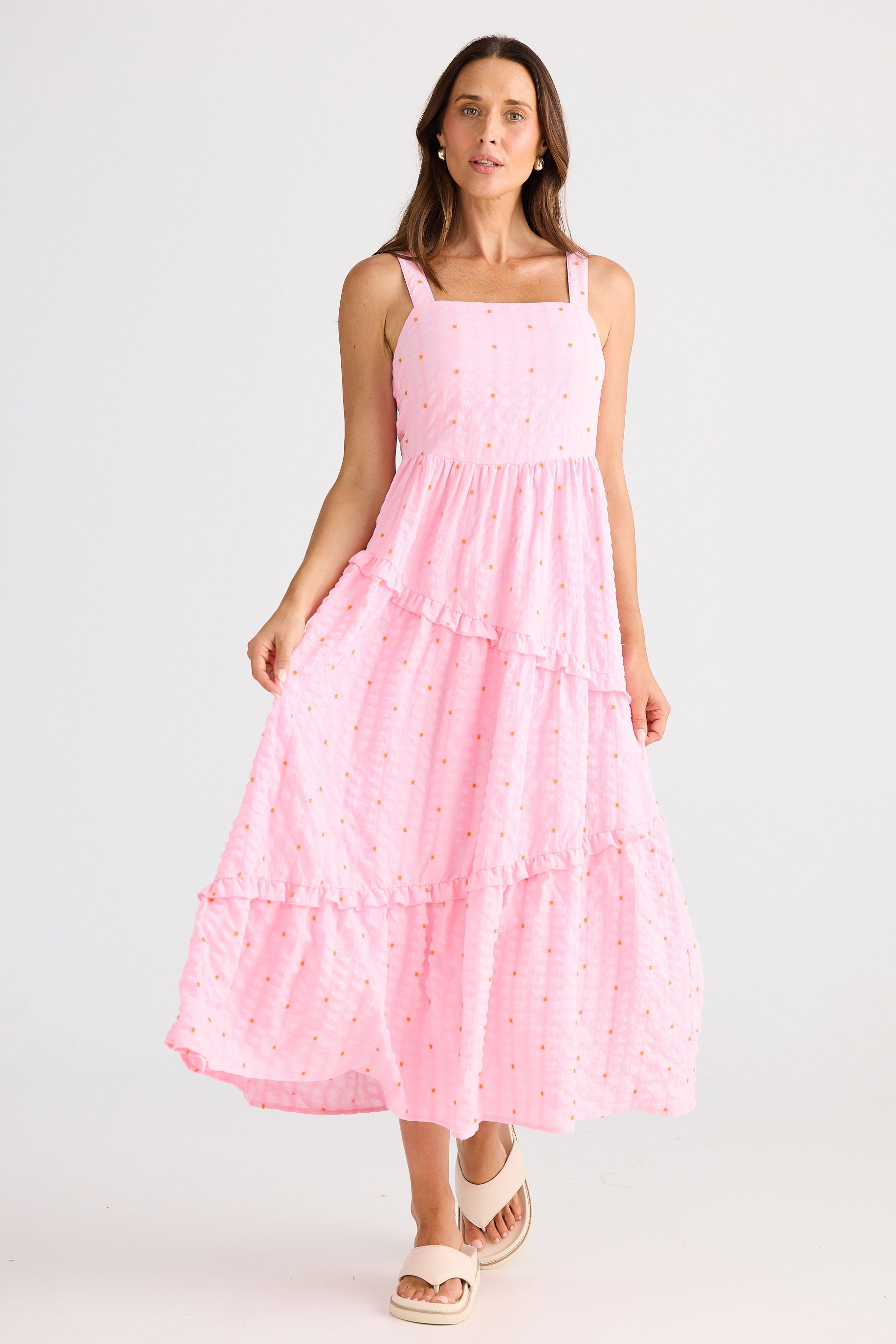 Woman wearing a pink dress with a white background