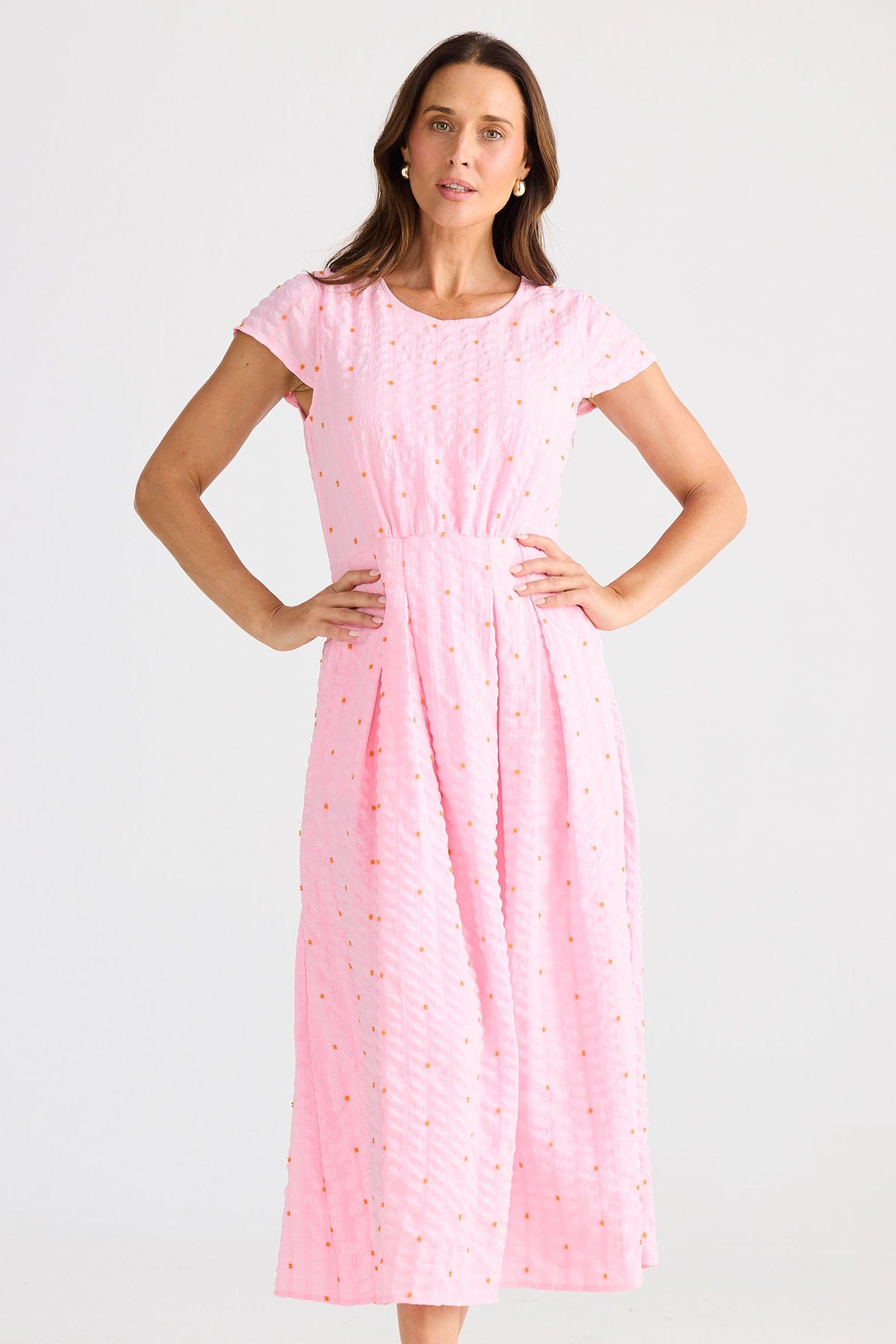 Woman wearing a pink dress with a white background
