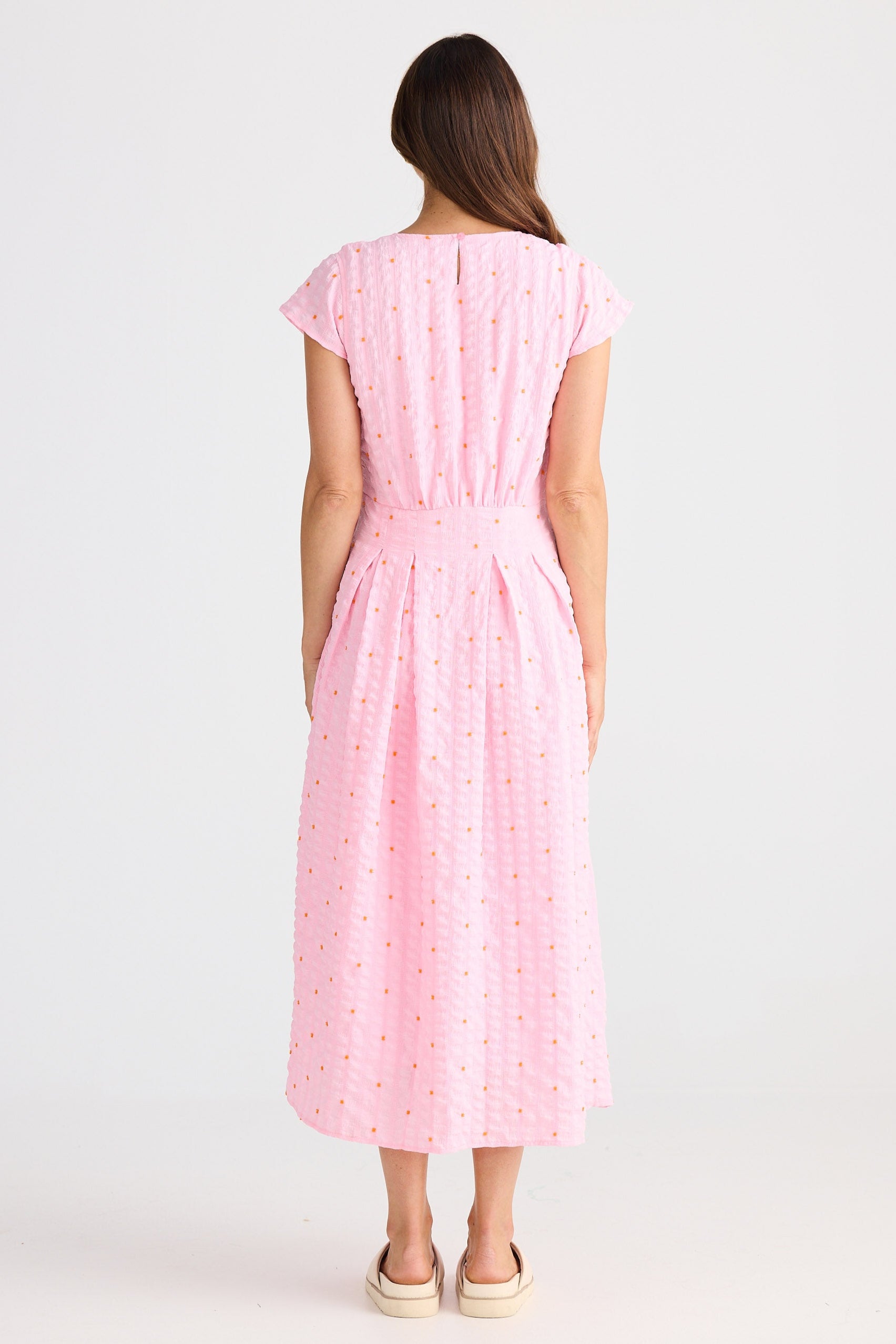 Woman wearing a pink dress on a white background