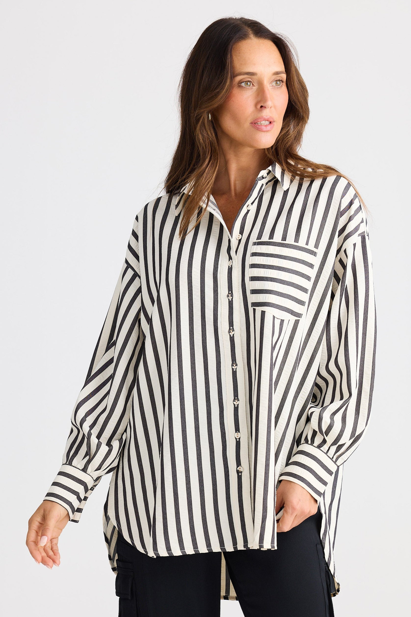 Woman wearing a black and white striped shirt against a plain background