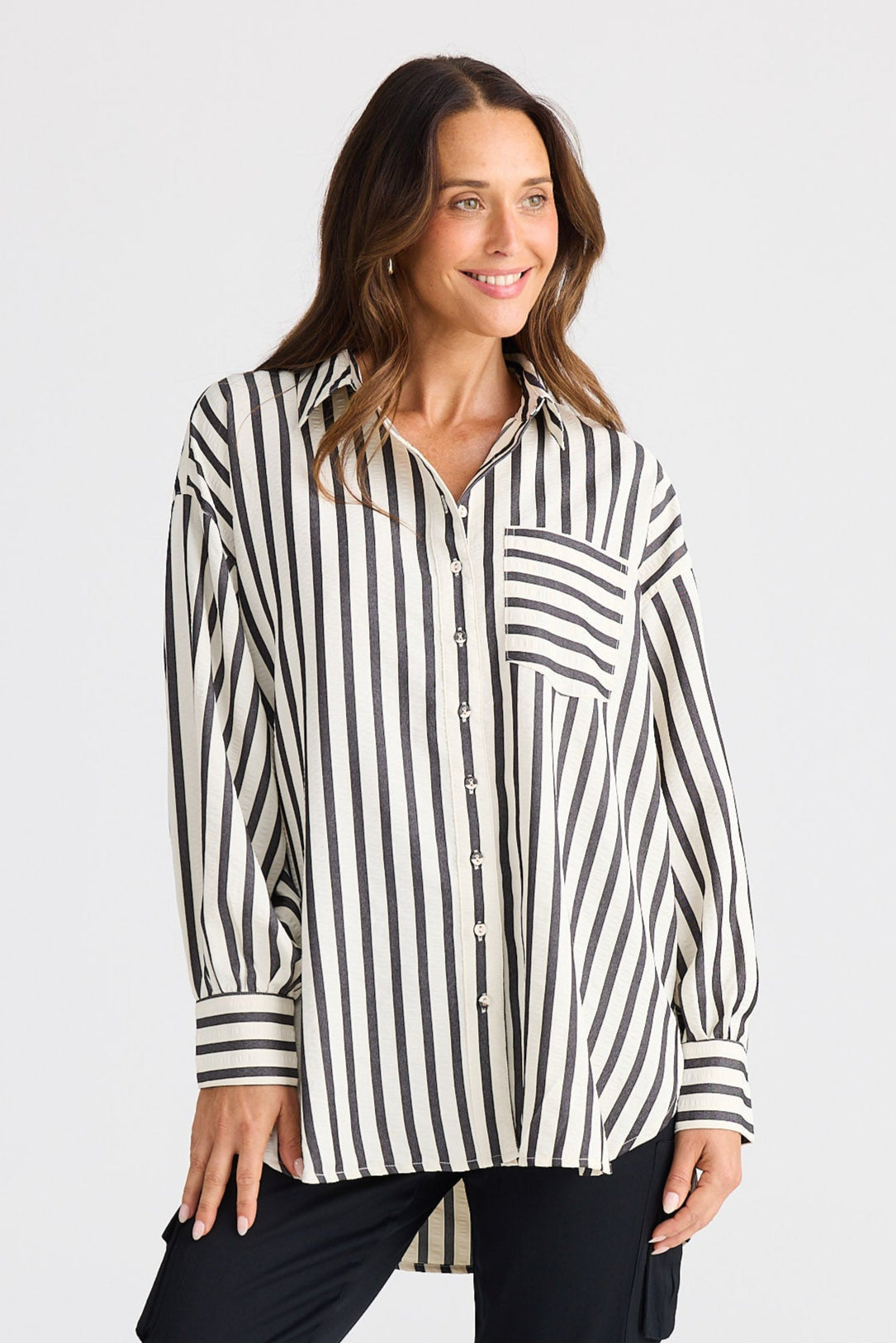 Woman wearing a black and white striped shirt with black pants on a white background