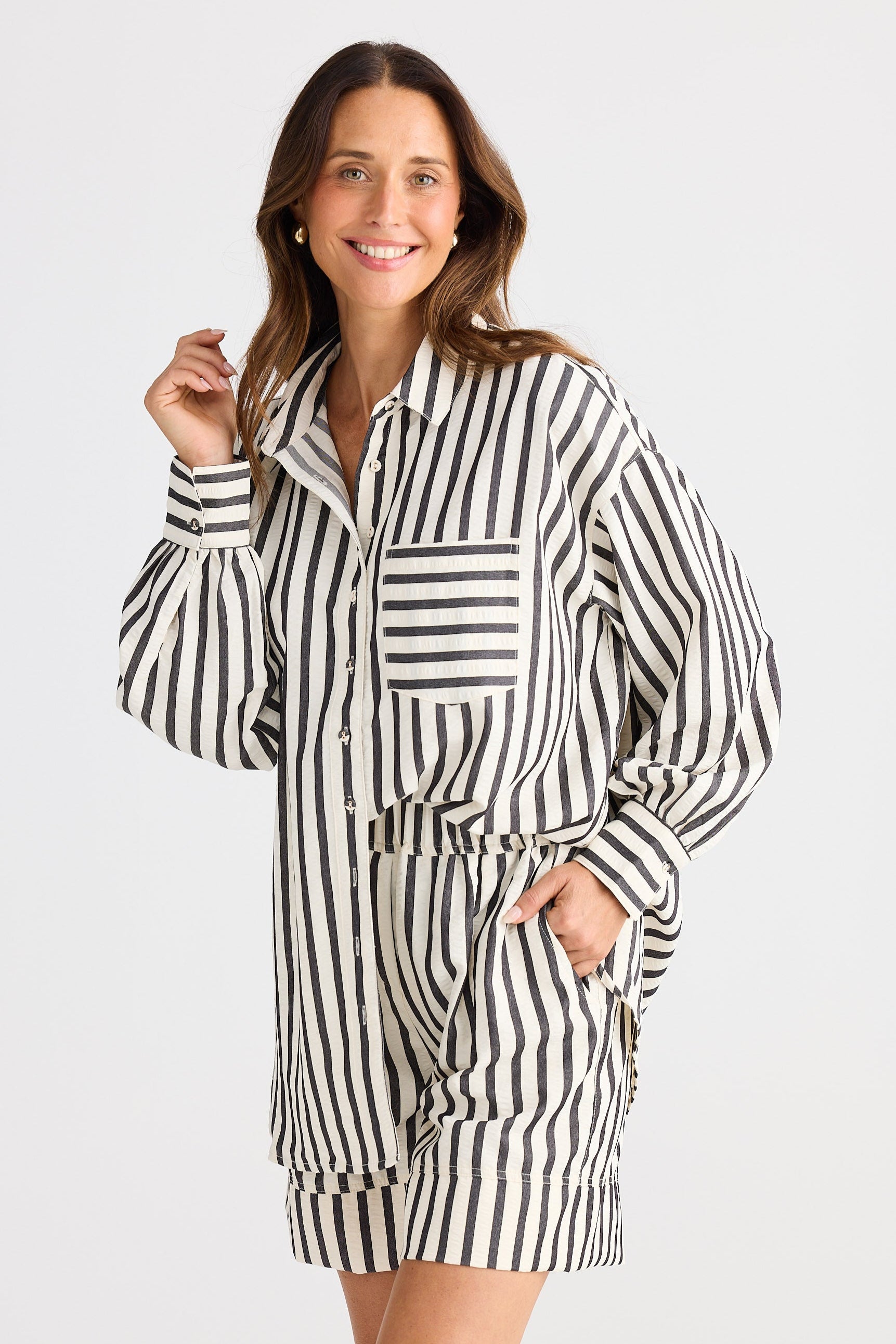 Woman wearing a black and white striped outfit on a plain background