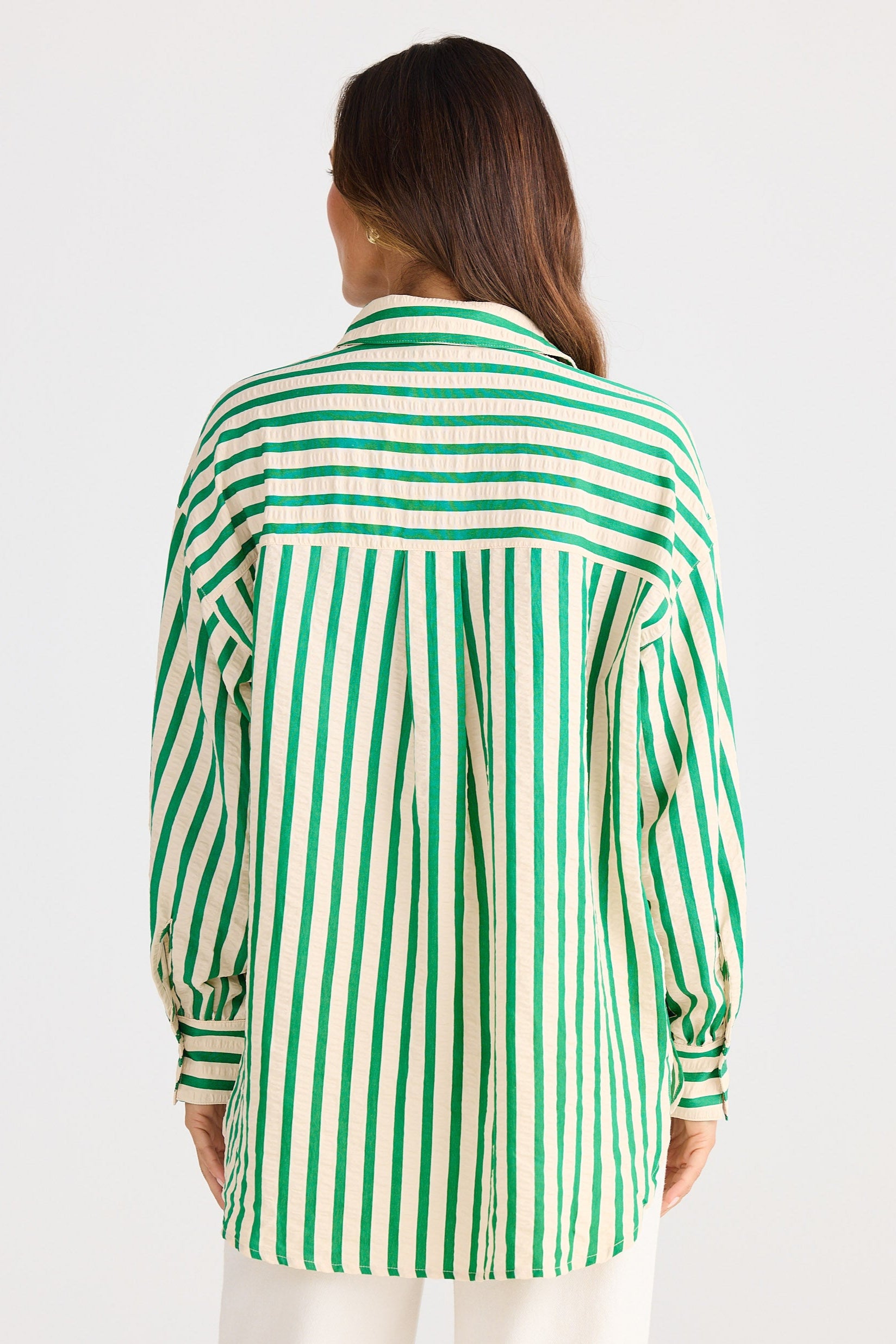 Person wearing a green and white striped shirt on a white background