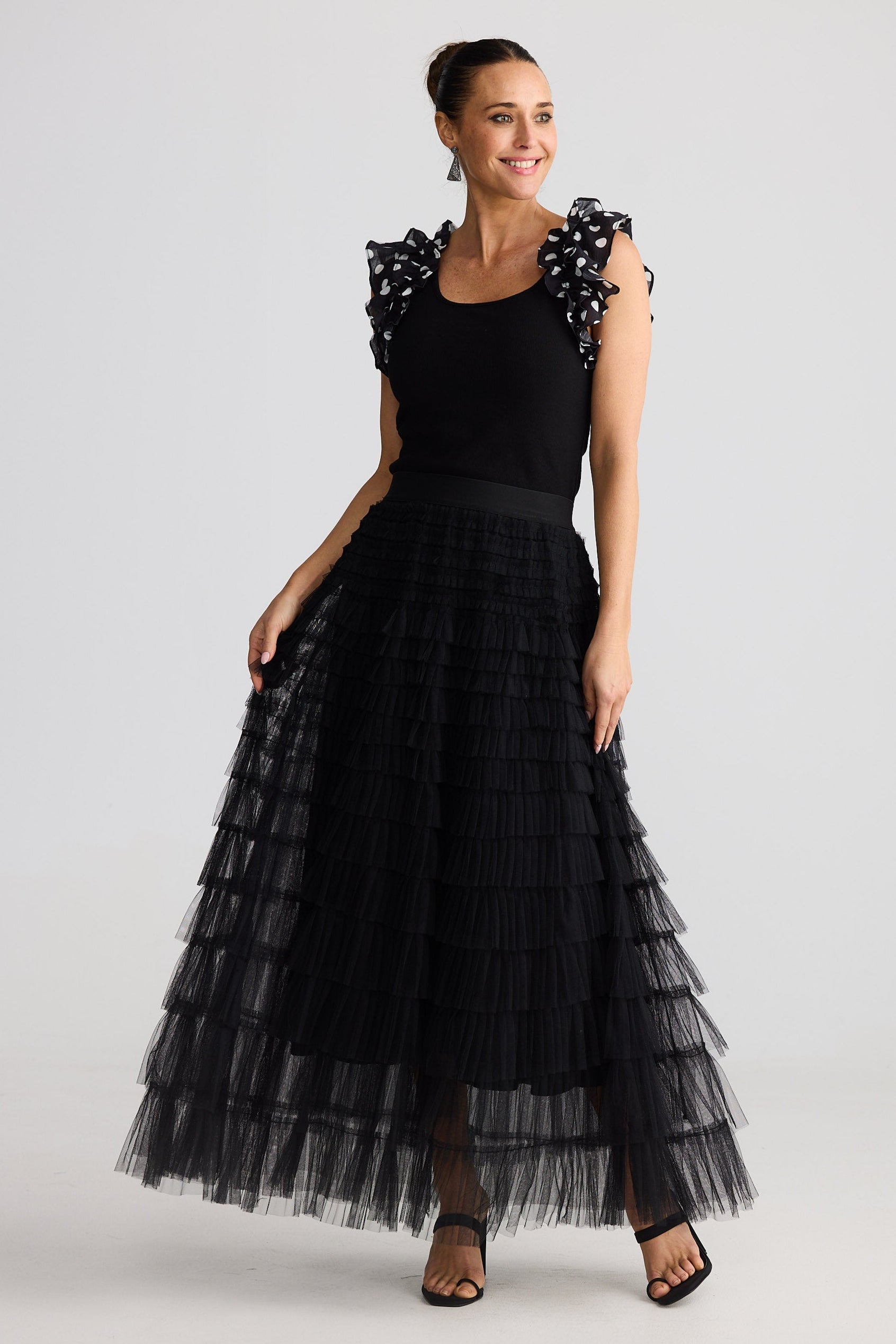 Woman wearing a black dress with floral embellishments on a white background