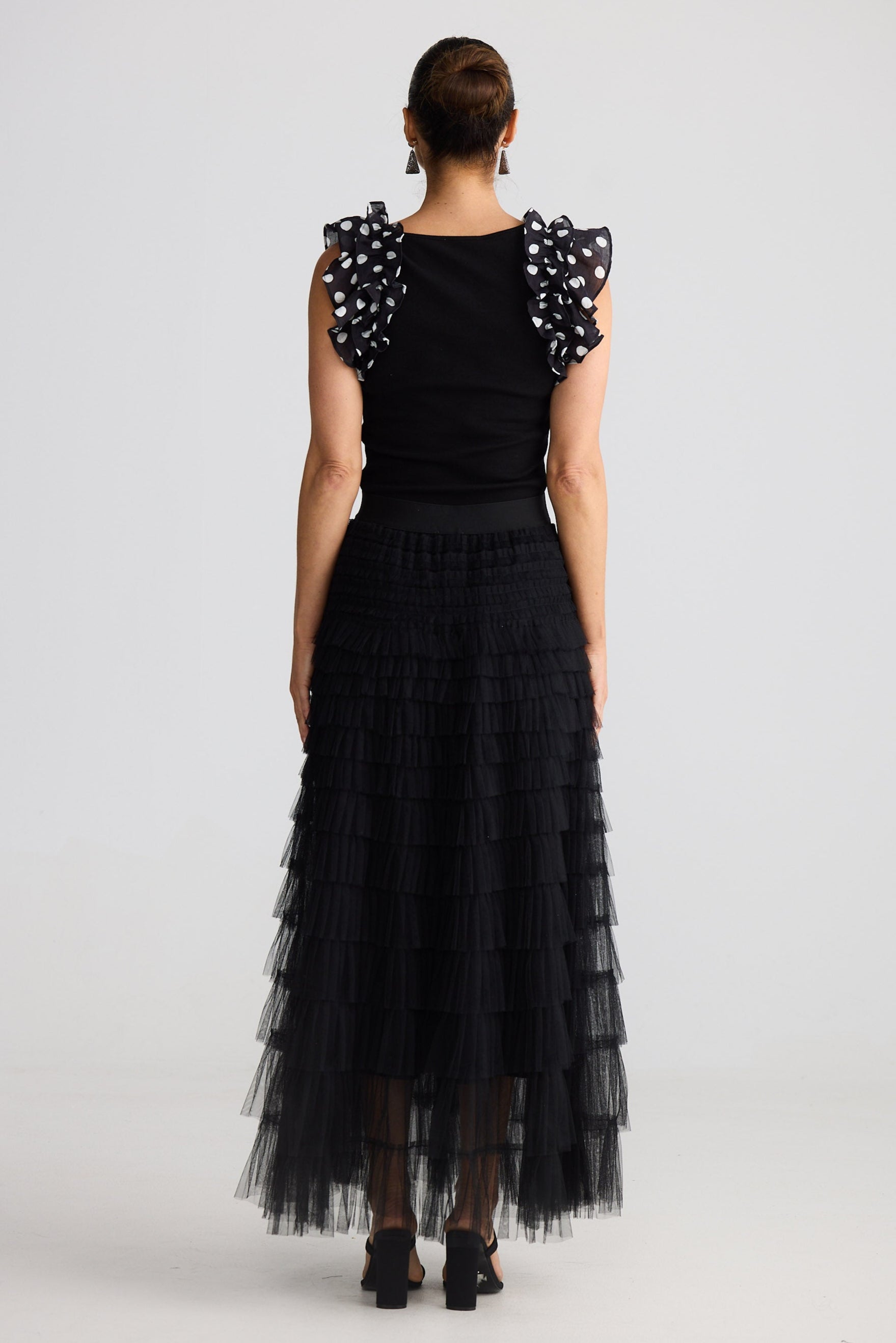 Woman wearing a black dress with floral sleeves on a white background