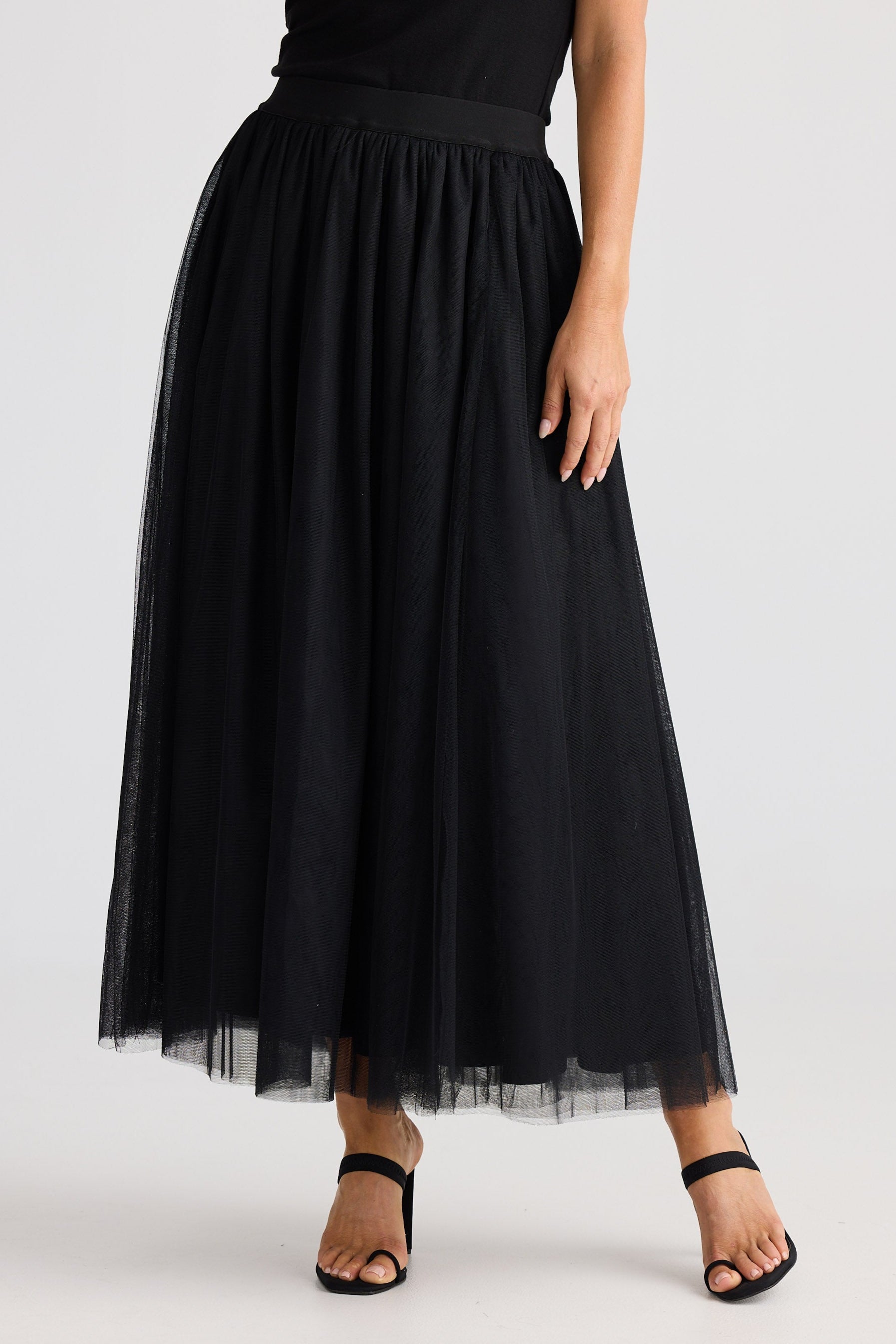 Black tulle skirt worn by a person on a white background