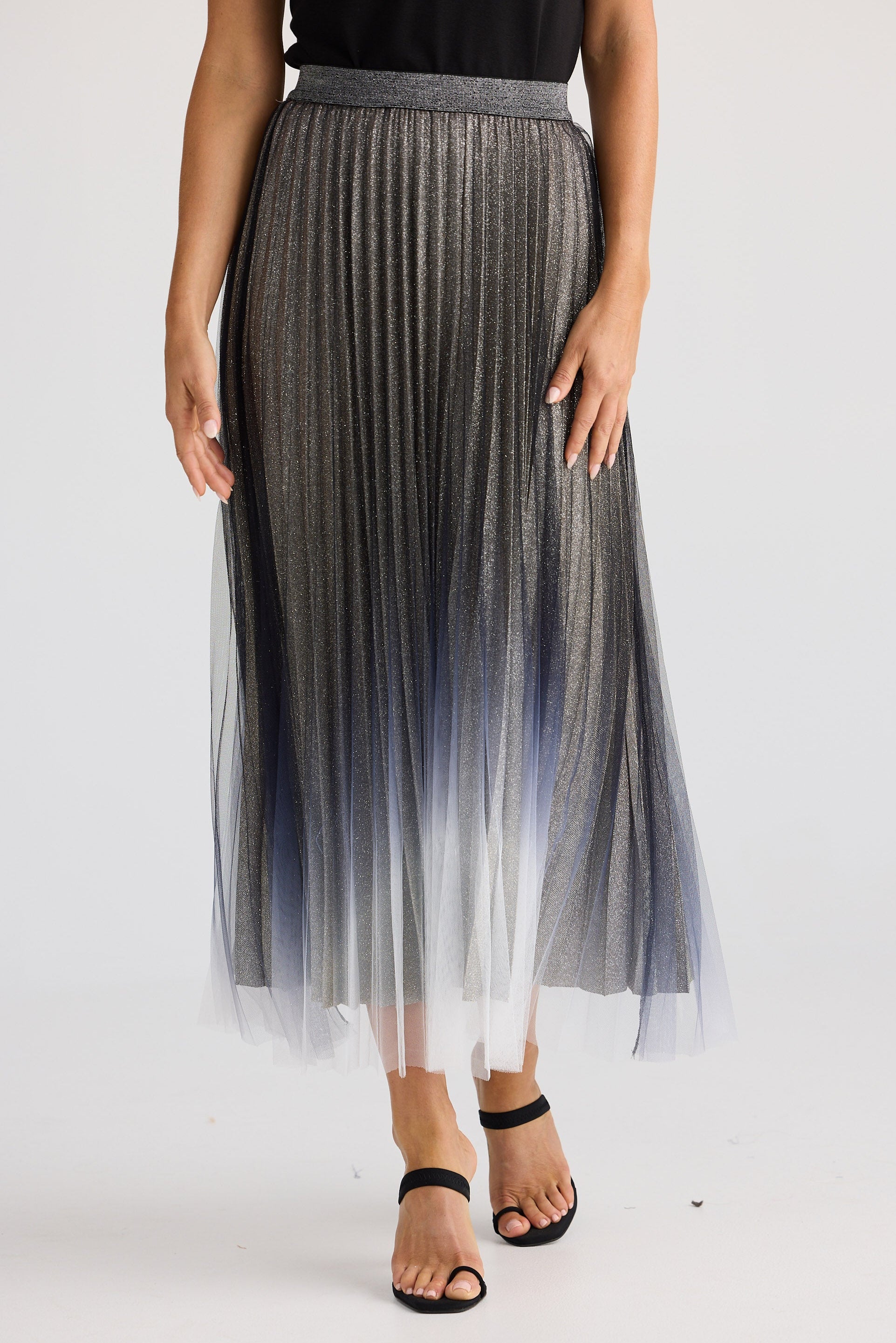 Person wearing a pleated skirt with a gradient effect on a white background