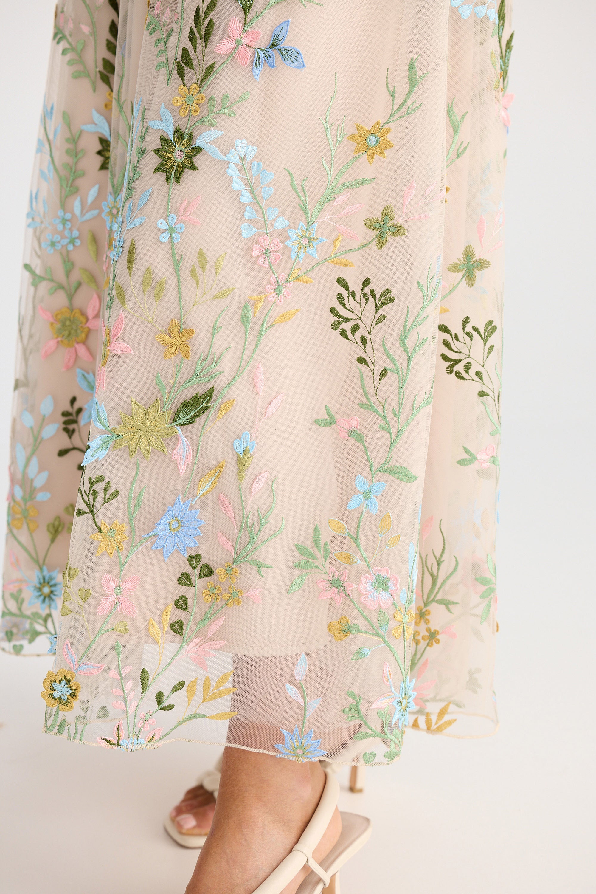 Sheer fabric with floral embroidery on a white background